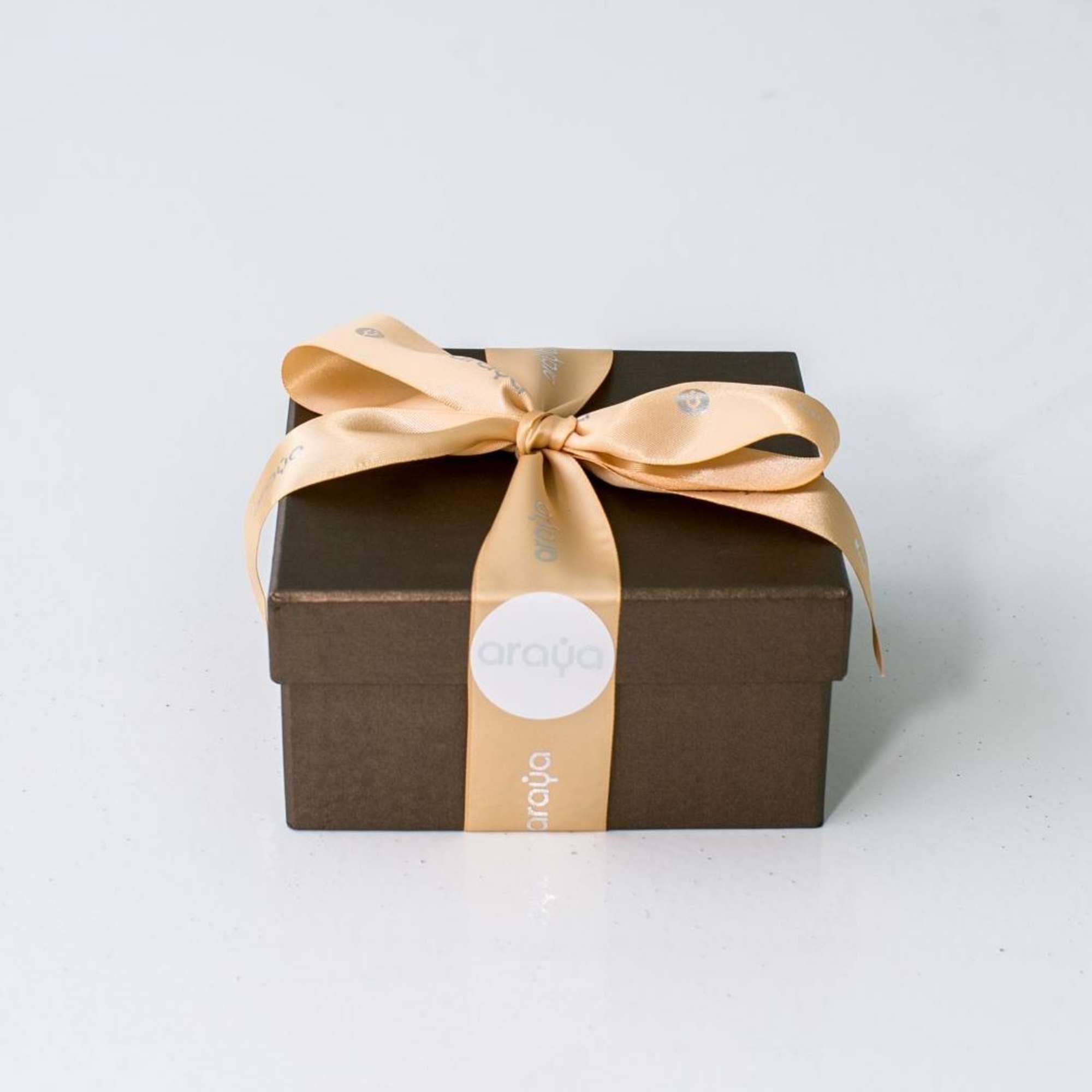 Brown gift box tied with a gold satin ribbon