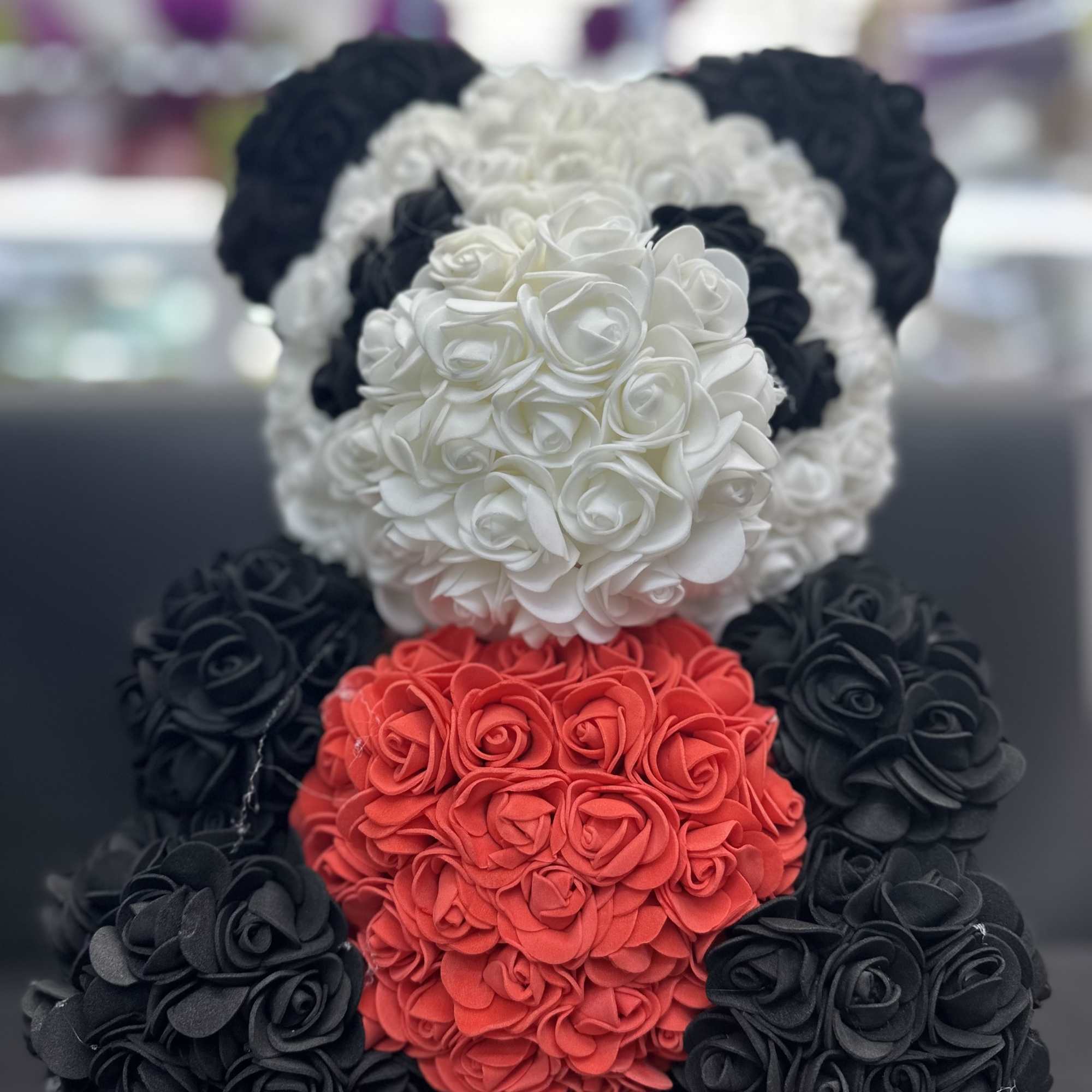 Three teddy bears made of roses in black, white, and red