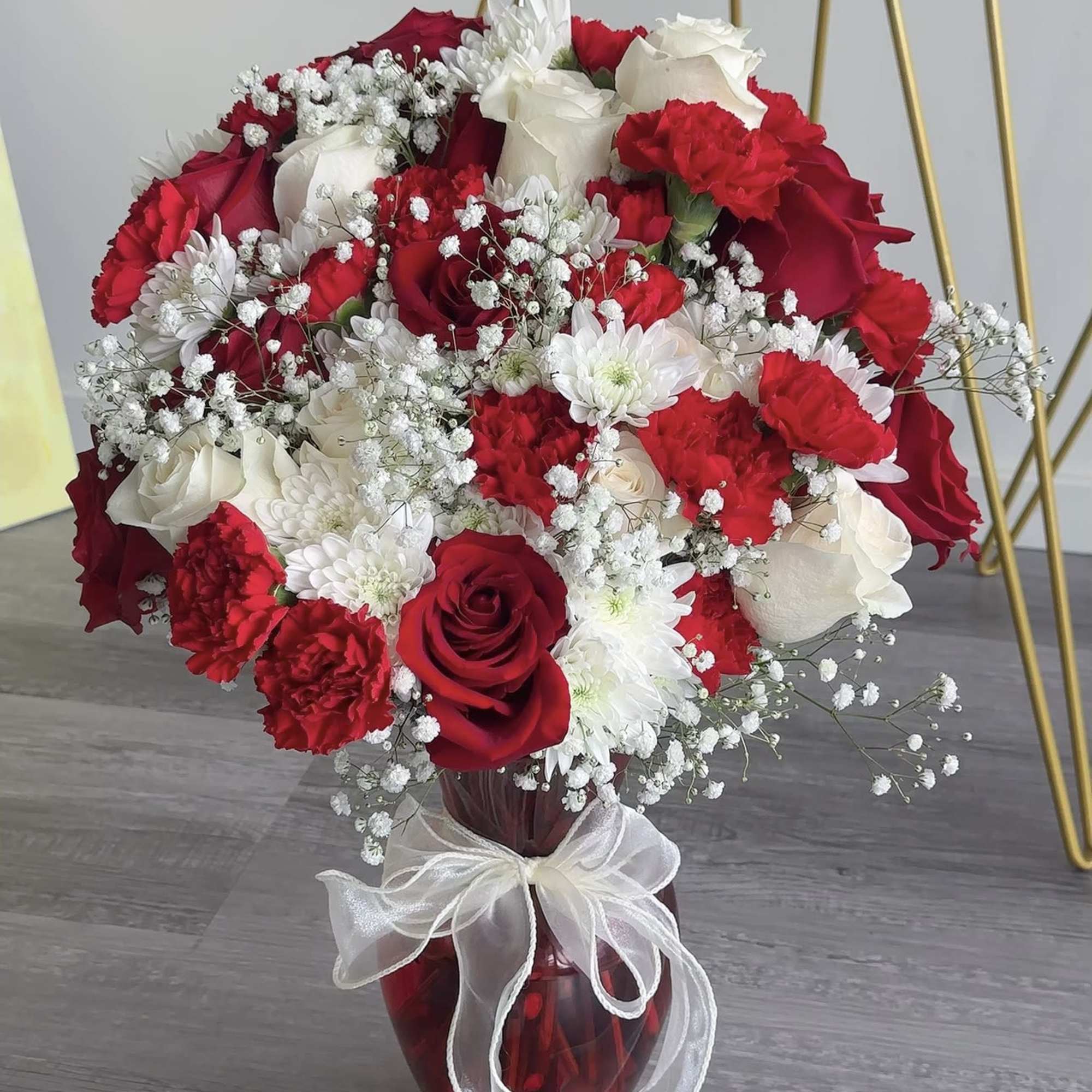 Red and white rose bouquet in a red glass vase with a white ribbon, photo 3 of 3