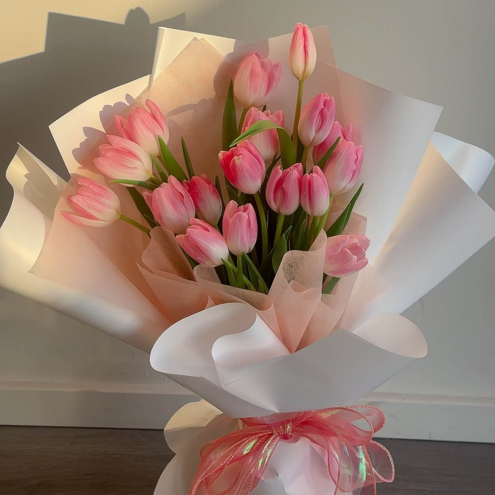 Bouquet of pink tulips wrapped in white and blush paper