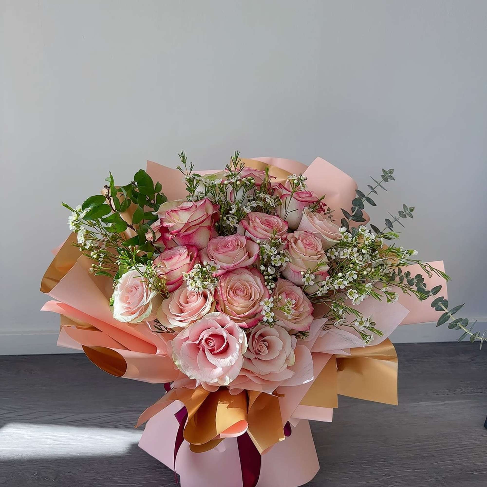 Bouquet of pink roses wrapped in pastel paper