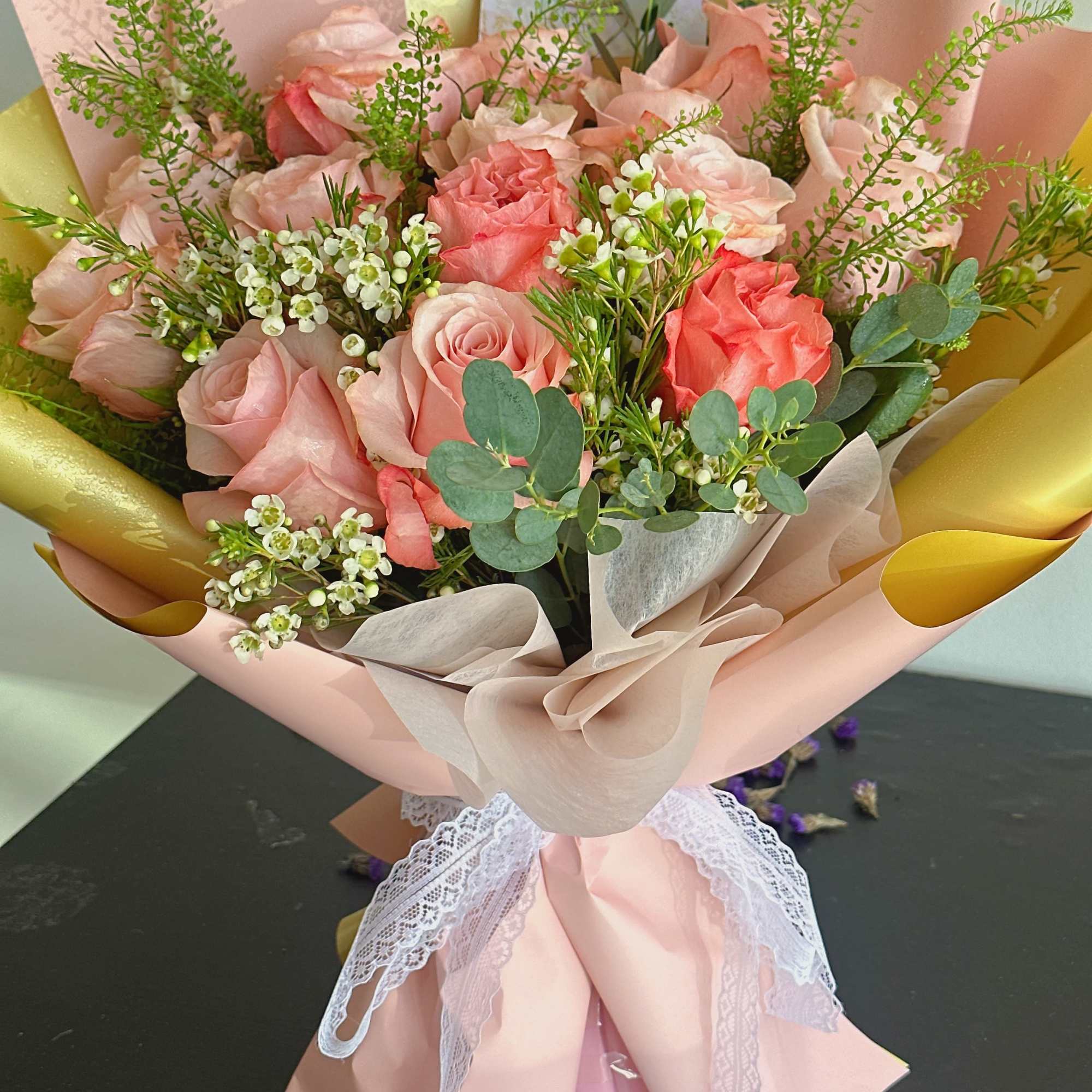 Pink rose bouquet wrapped in blush paper with lace ribbon
