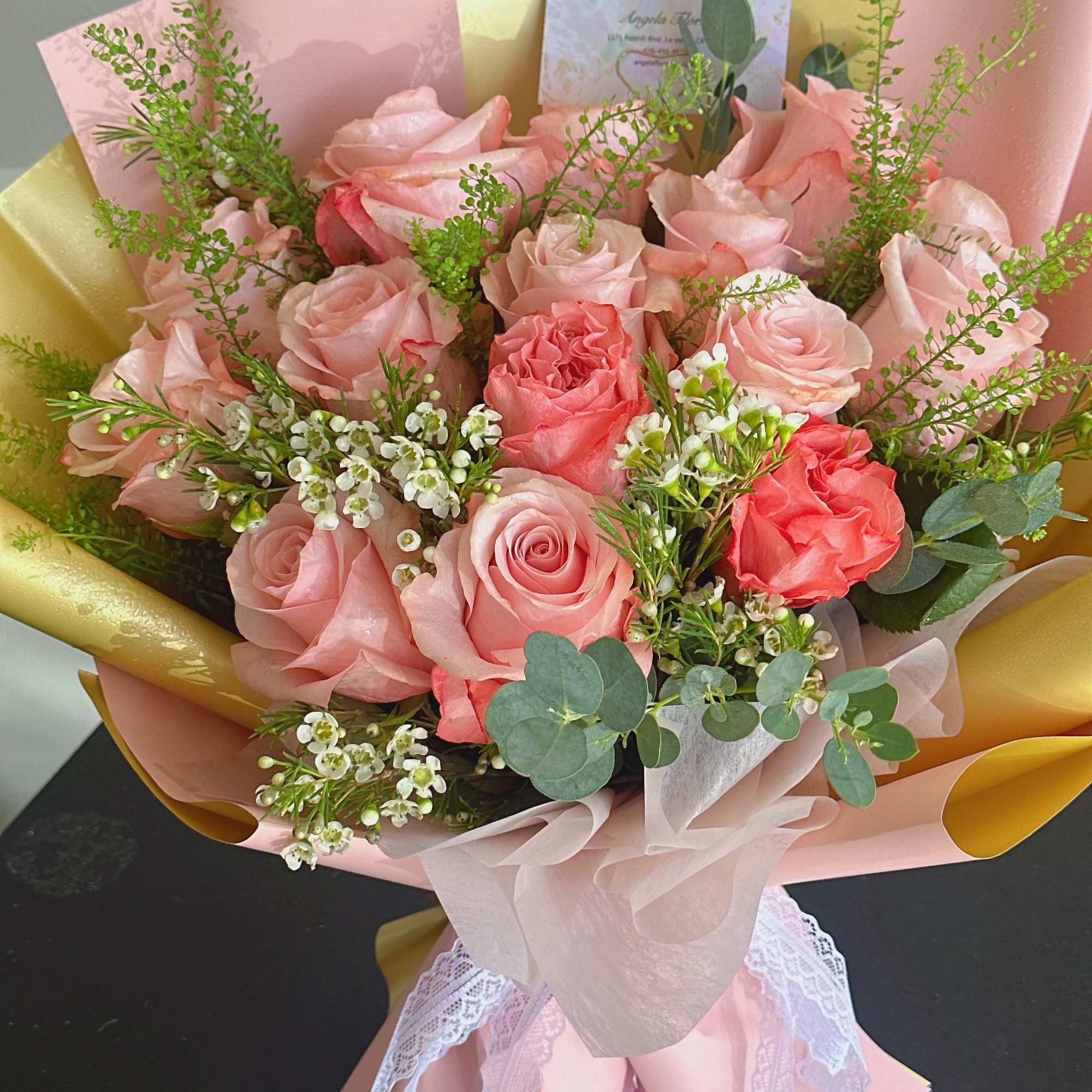 Bouquet of pink roses with white filler flowers and pink wrapping