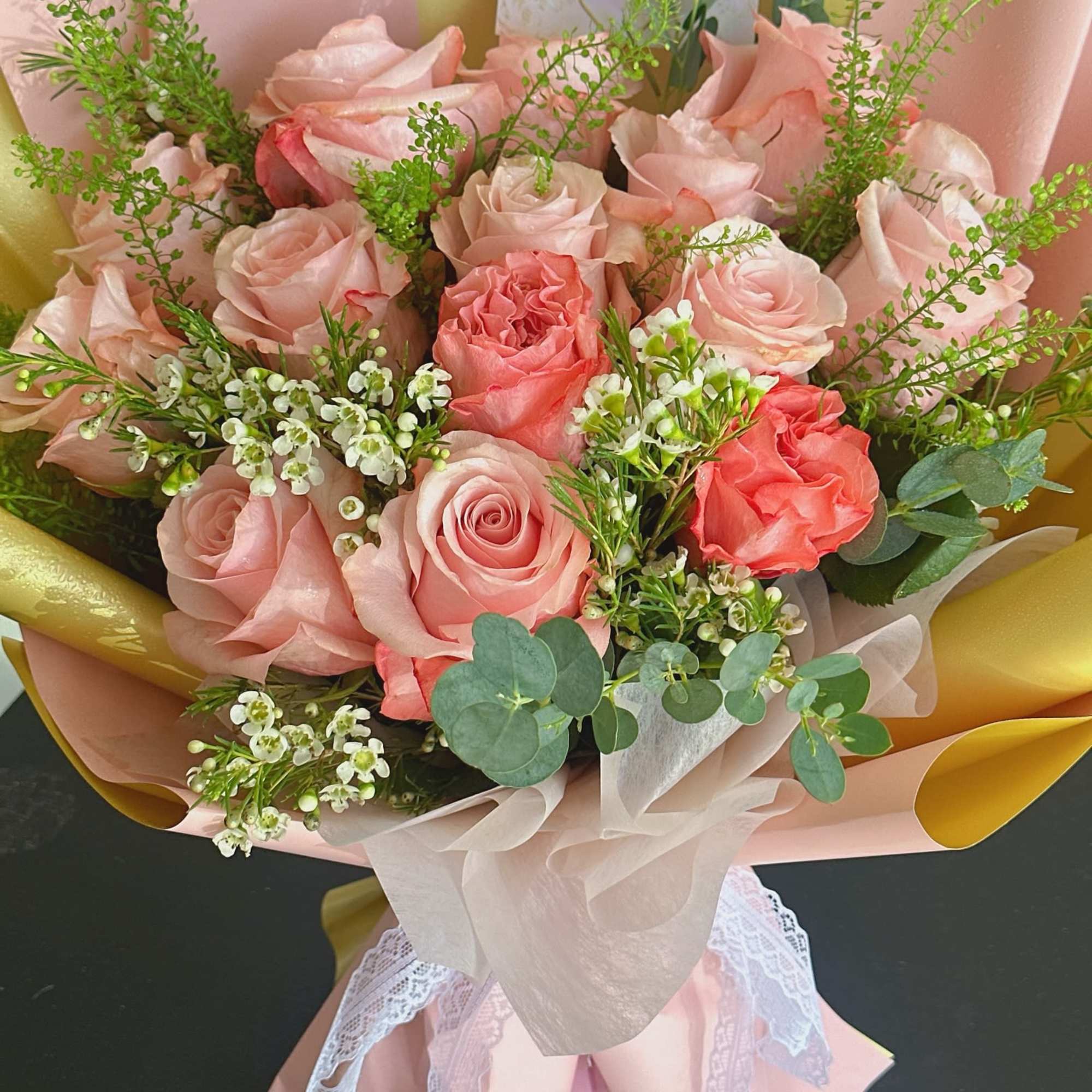 Bouquet of pale pink and coral roses with white filler flowers