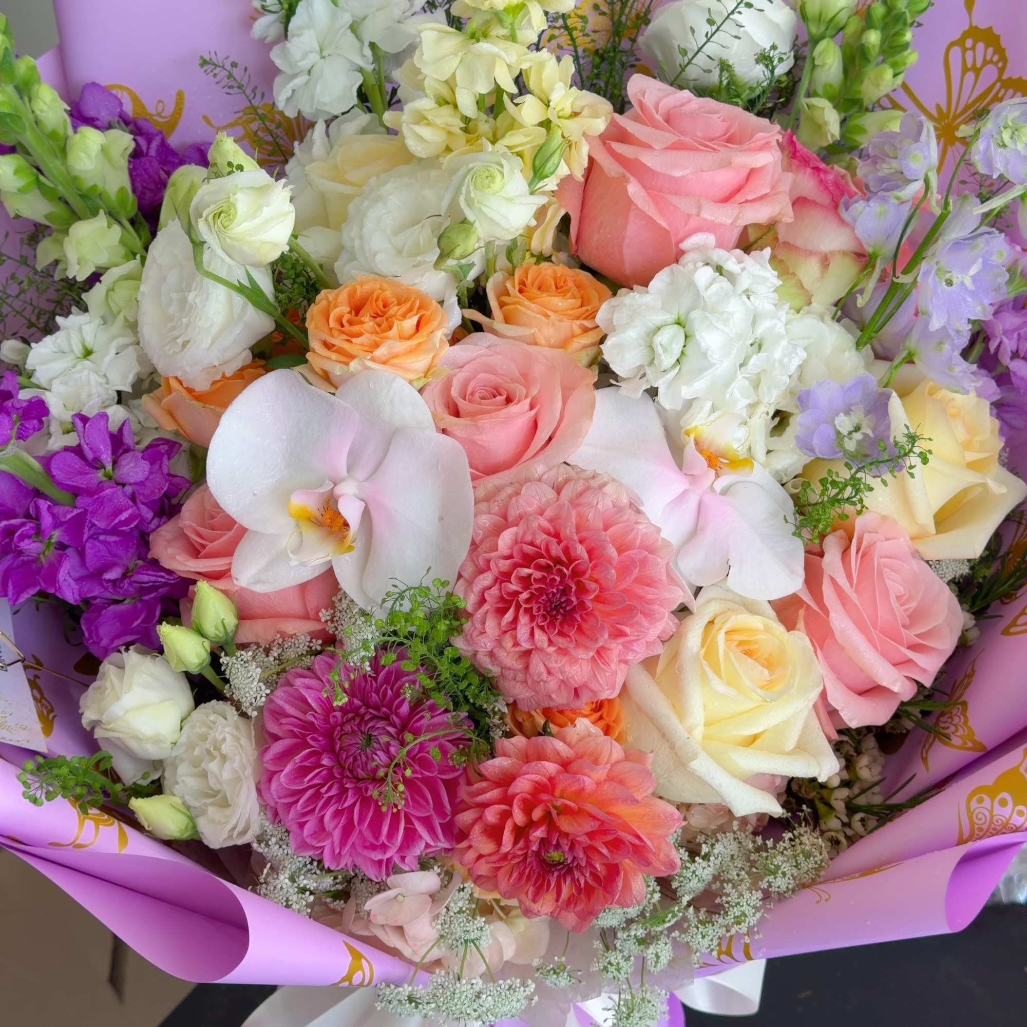 Mixed bouquet of pink, white, and purple flowers wrapped in lavender paper, photo 4 of 5
