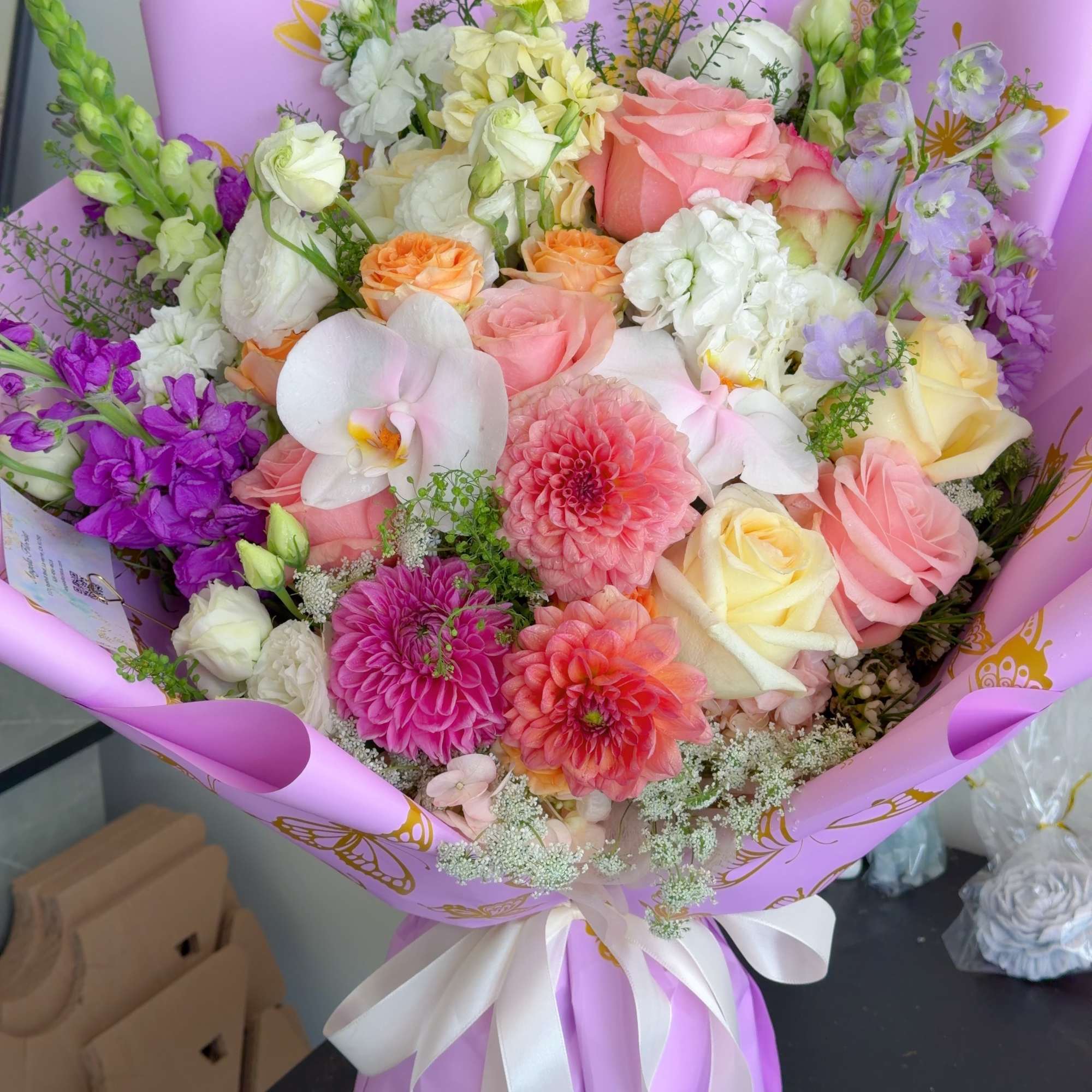 Mixed bouquet of pink, white, and purple flowers wrapped in lavender paper, photo 2 of 5
