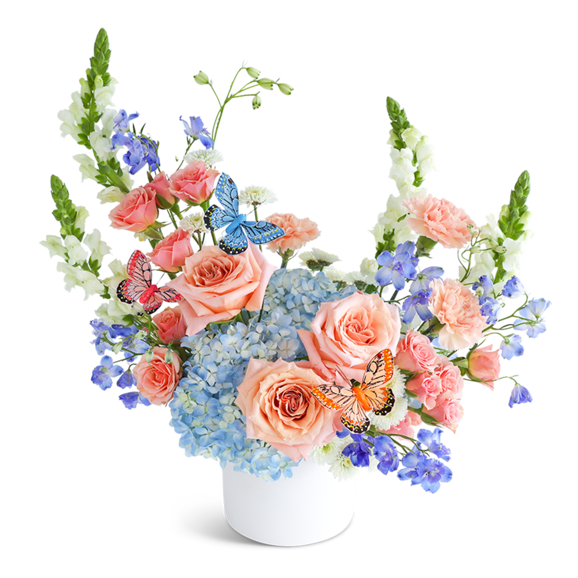Peach roses and blue hydrangeas in a white vase with butterfly picks