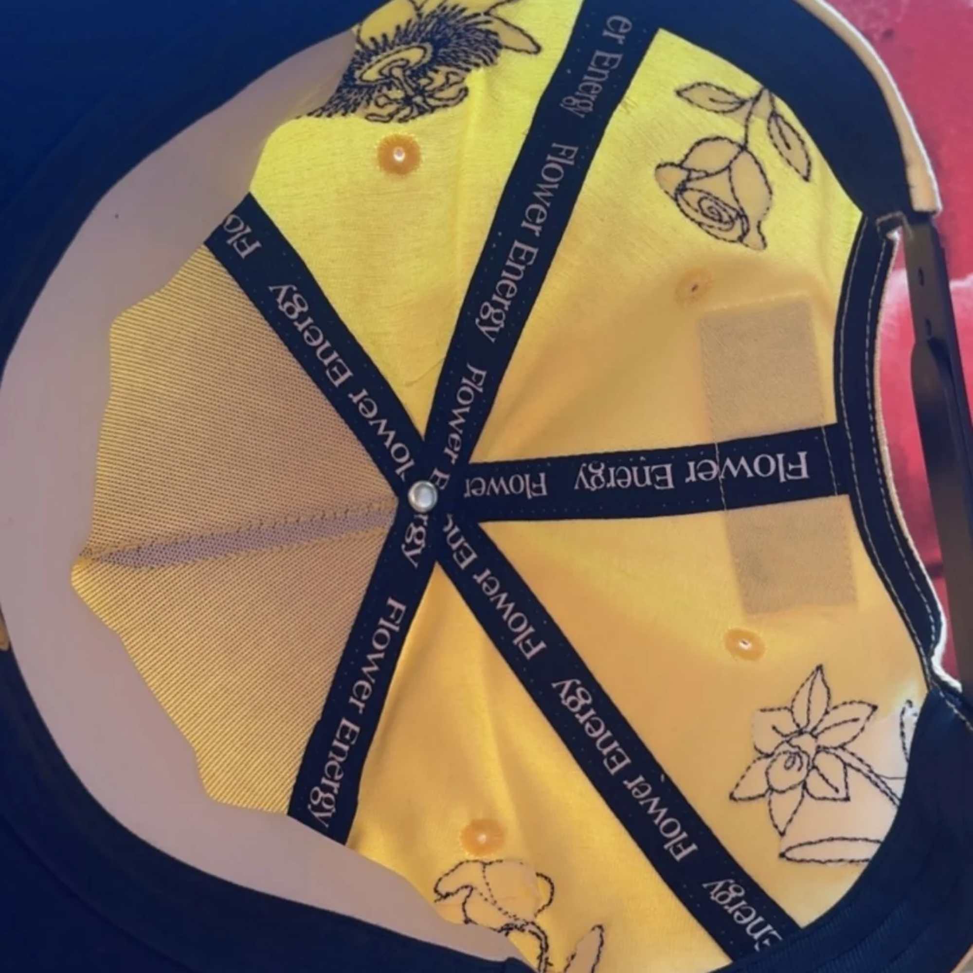 Yellow cap with floral embroidery and navy trim