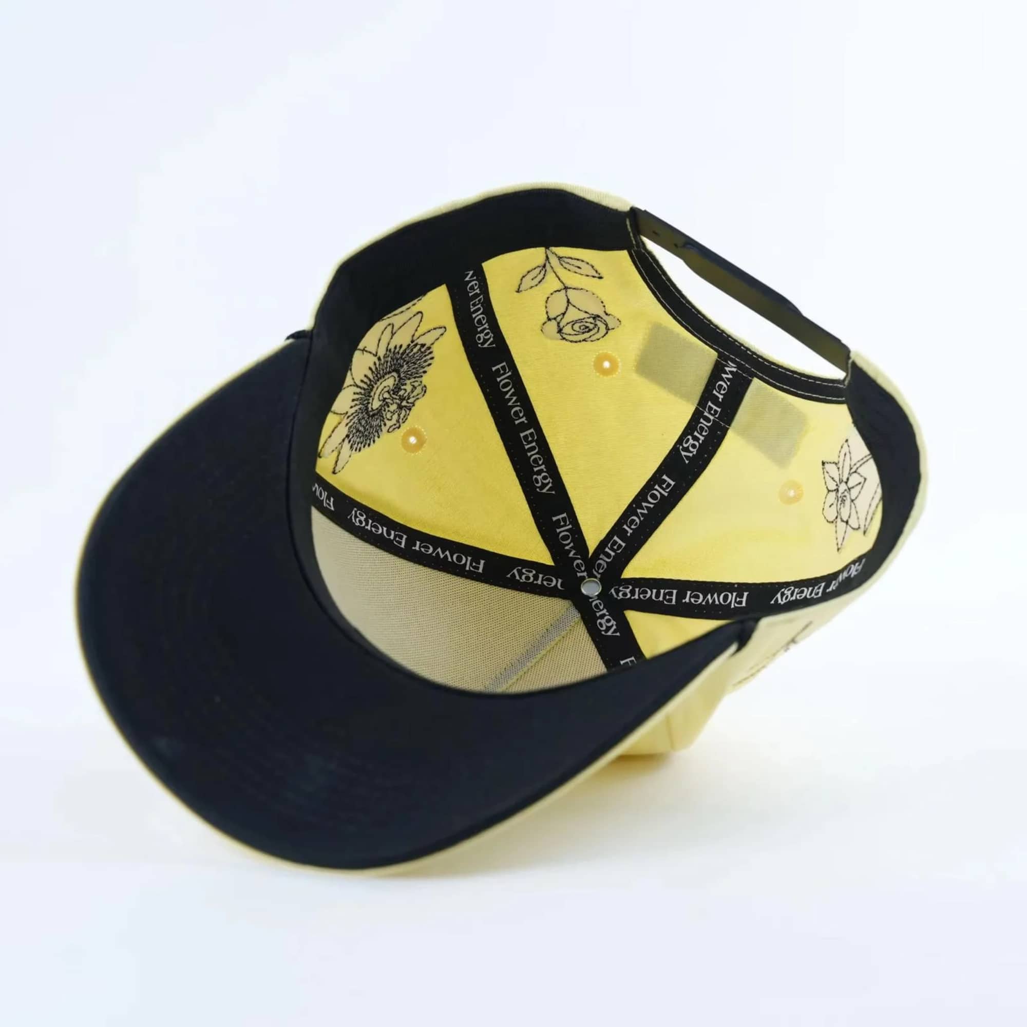Black and yellow baseball cap with floral graphics and text
