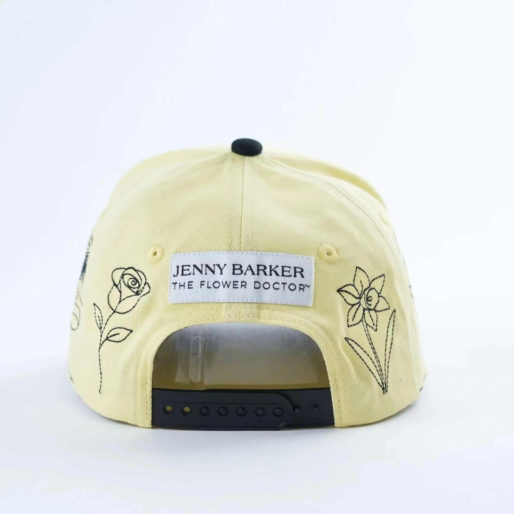 Yellow baseball cap with floral line drawings and a Jenny Barker label