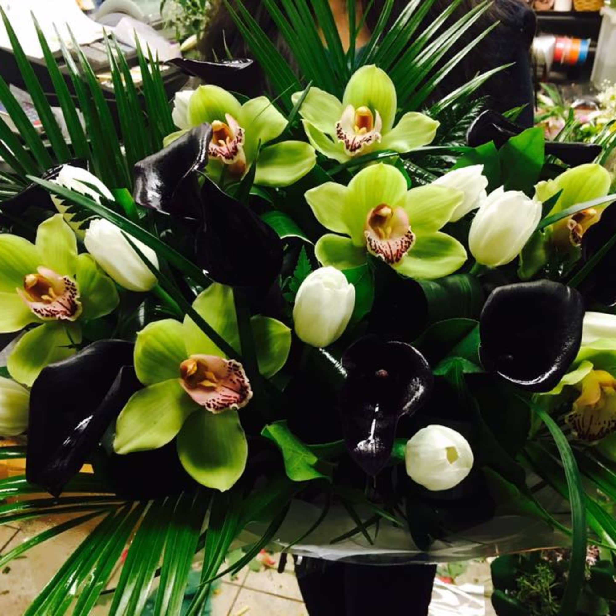Green orchids and black calla lilies in a floral arrangement
