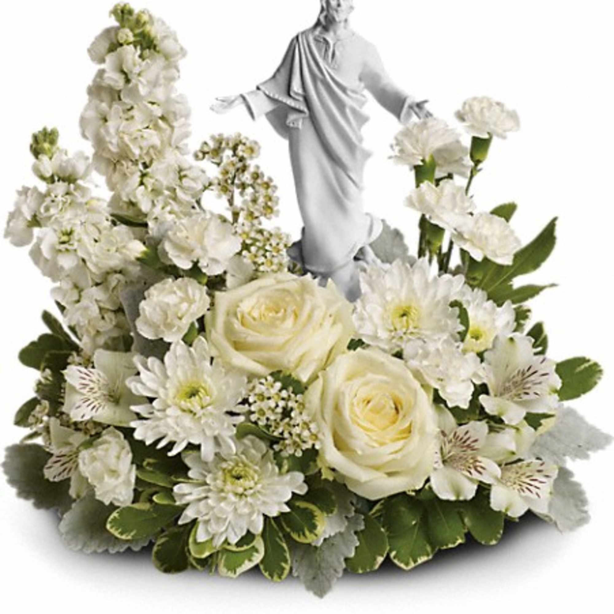 White floral arrangement with a small statue of Jesus at the center