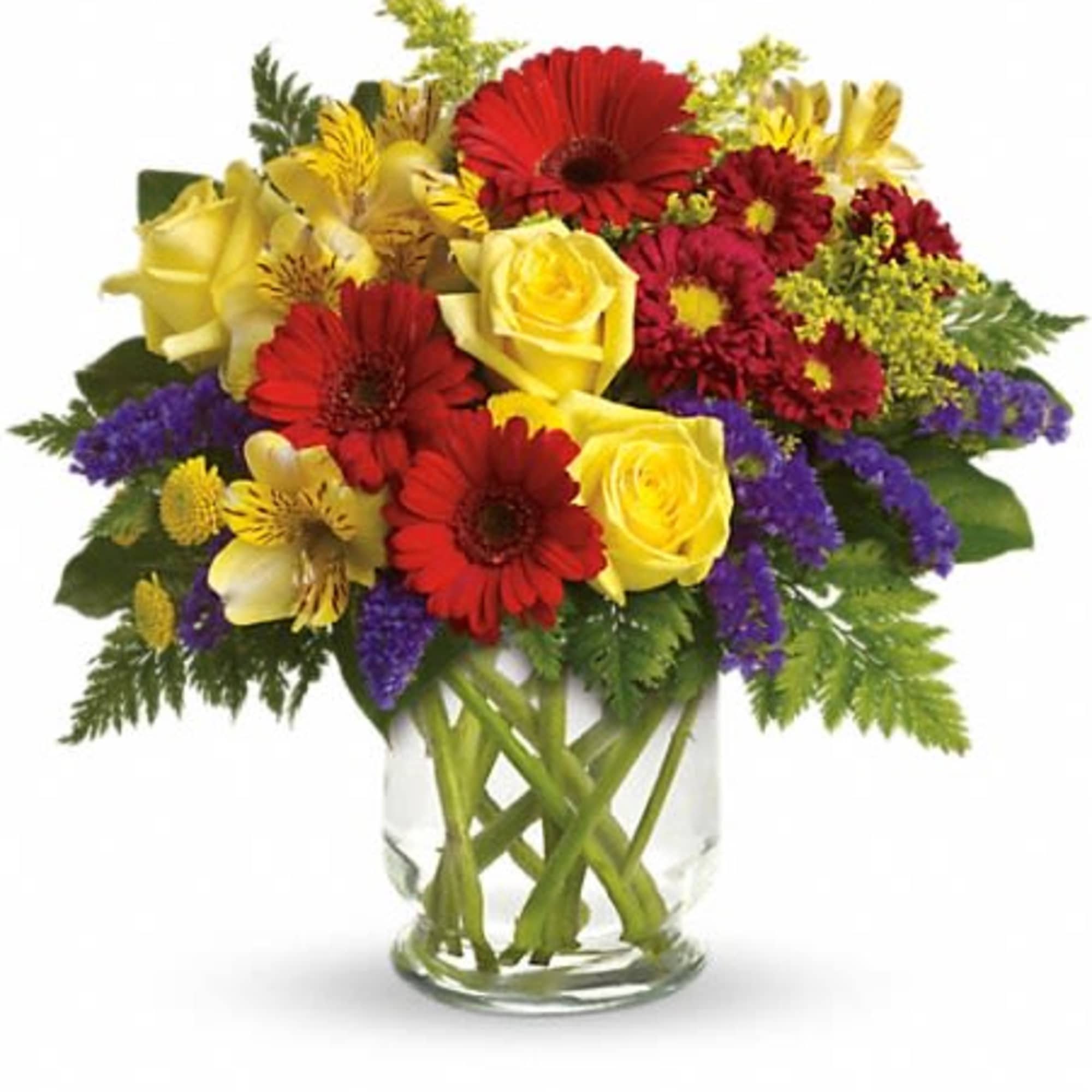 Mixed bouquet of red, yellow, and purple flowers in a clear glass vase