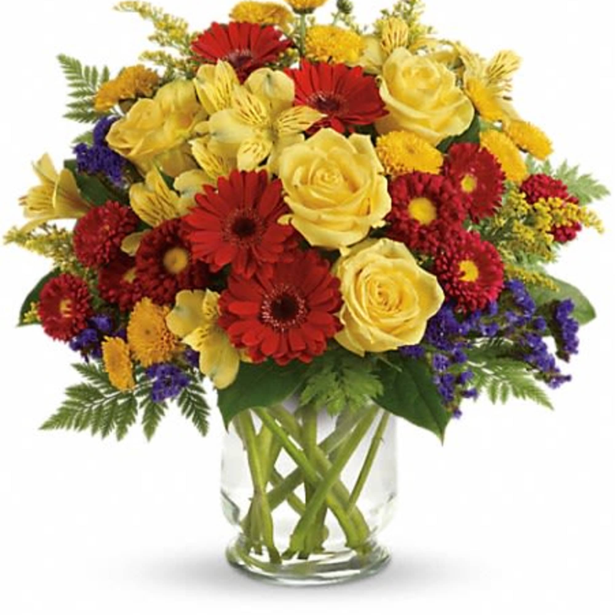 Mixed bouquet of yellow and red flowers in a clear glass vase