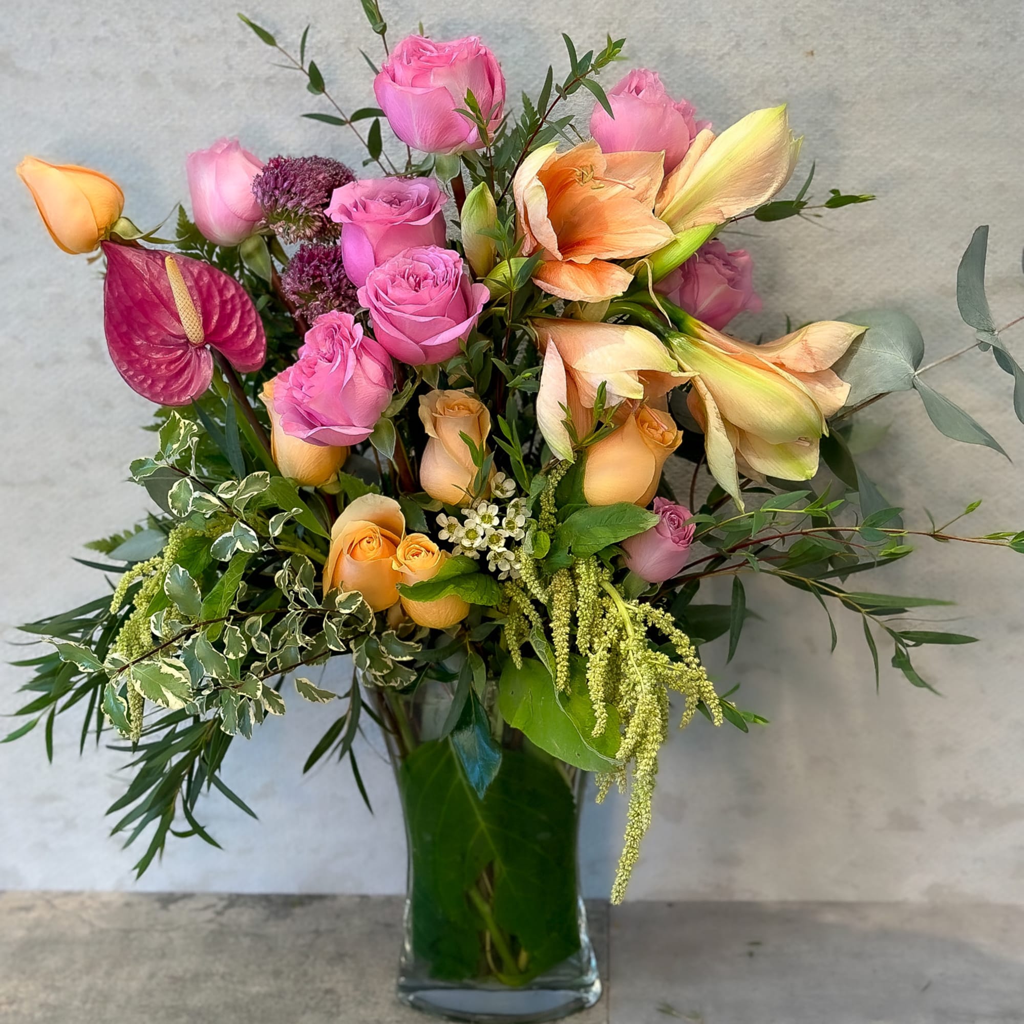 Mixed pink and peach roses in a clear glass vase
