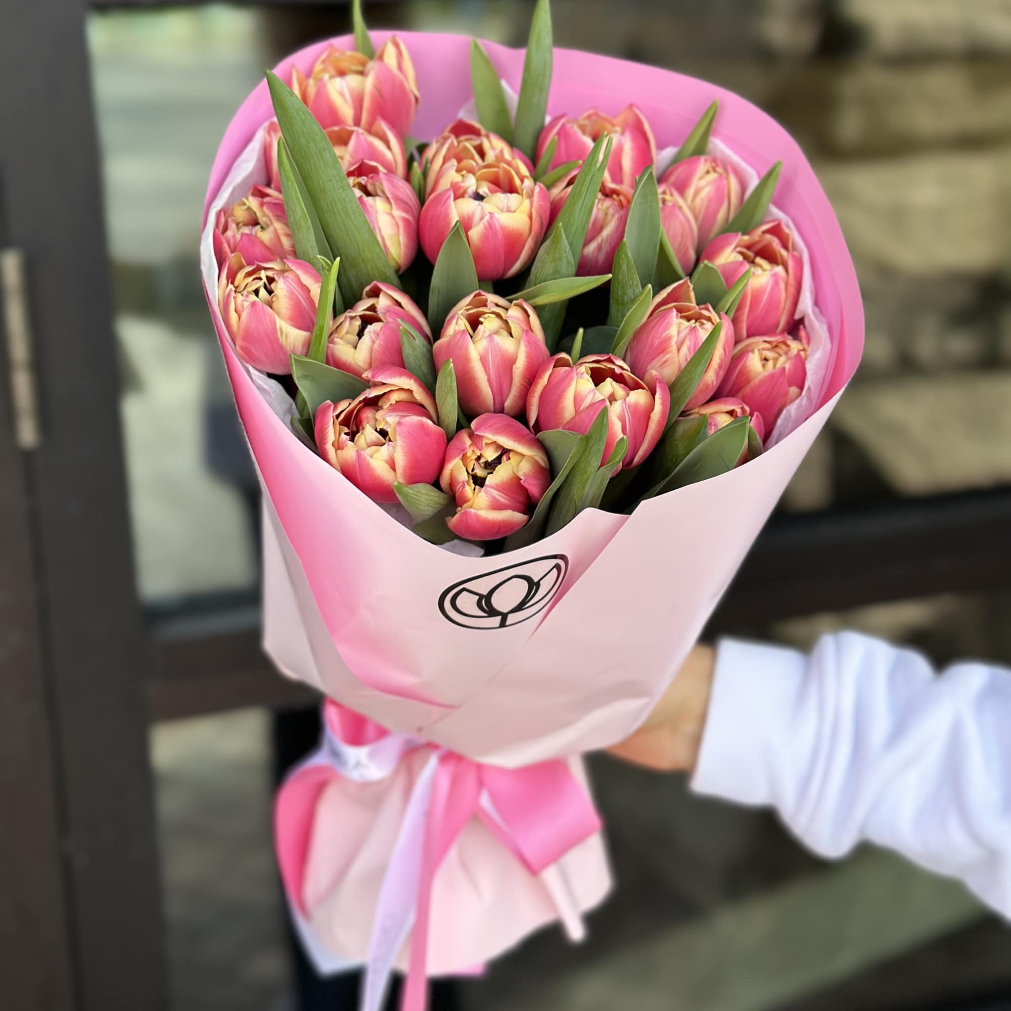 Bouquet of pink tulips wrapped in pink paper with a ribbon