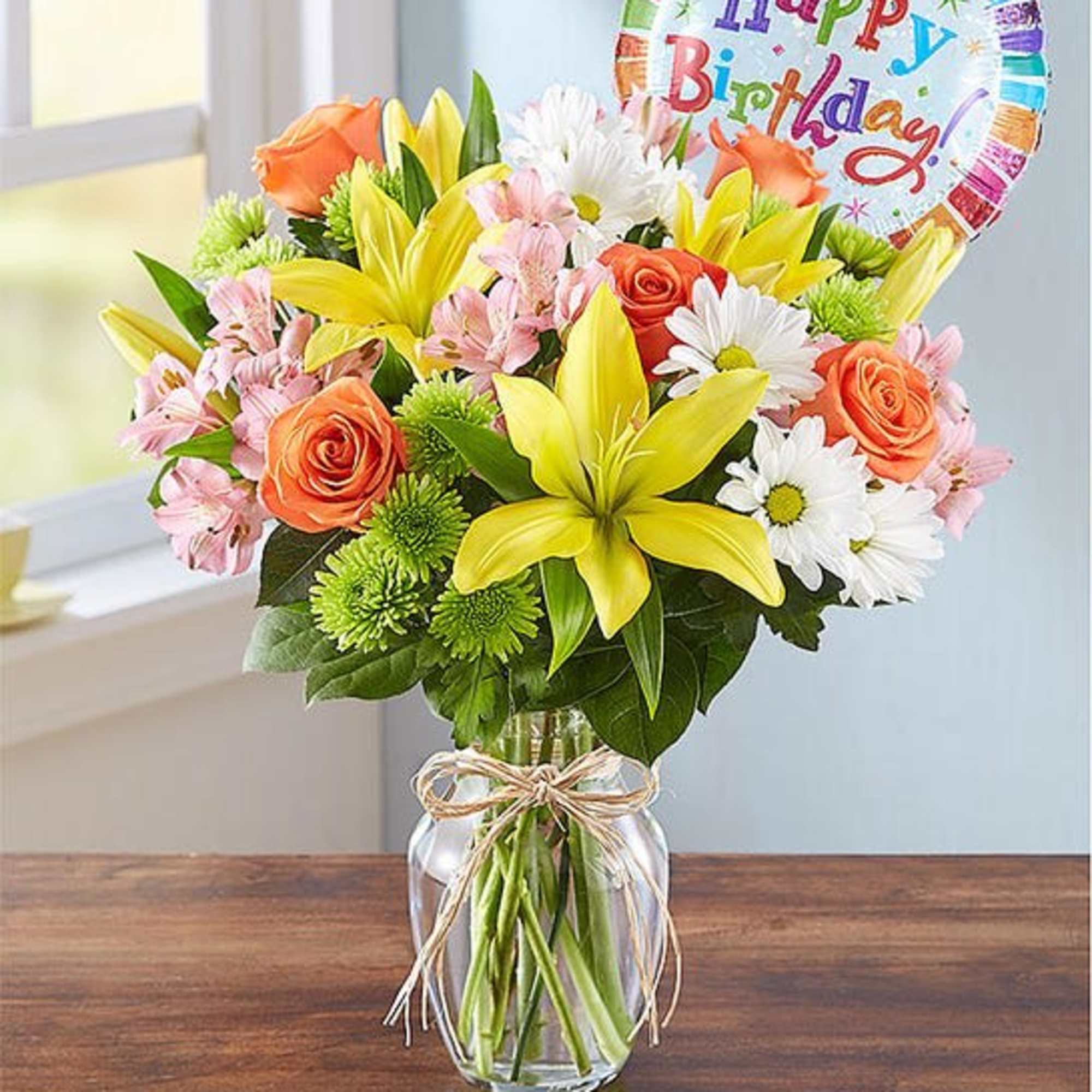 Mixed bouquet in a glass vase with a birthday balloon