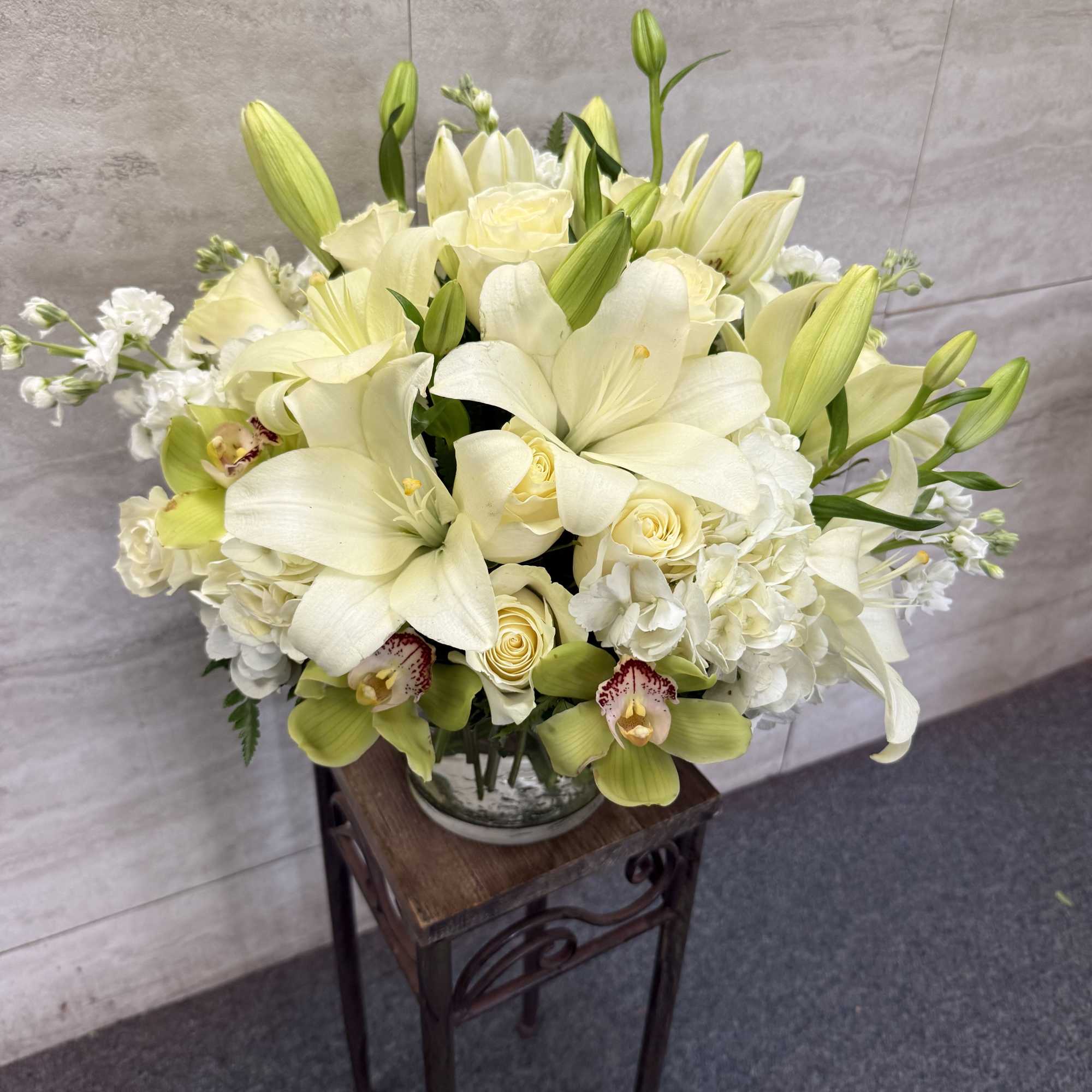 All-white arrangement of lilies, roses and orchids for a timeless, elegant touch-perfect