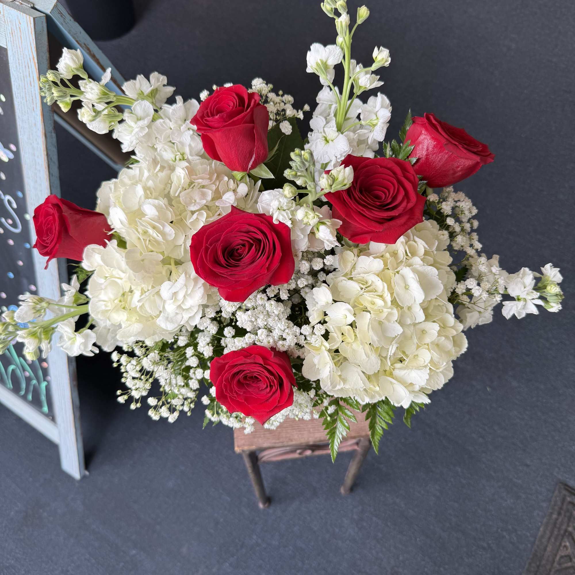 Vivid red roses and lush white hydrangeas with airy white fillers in, photo 2 of 2