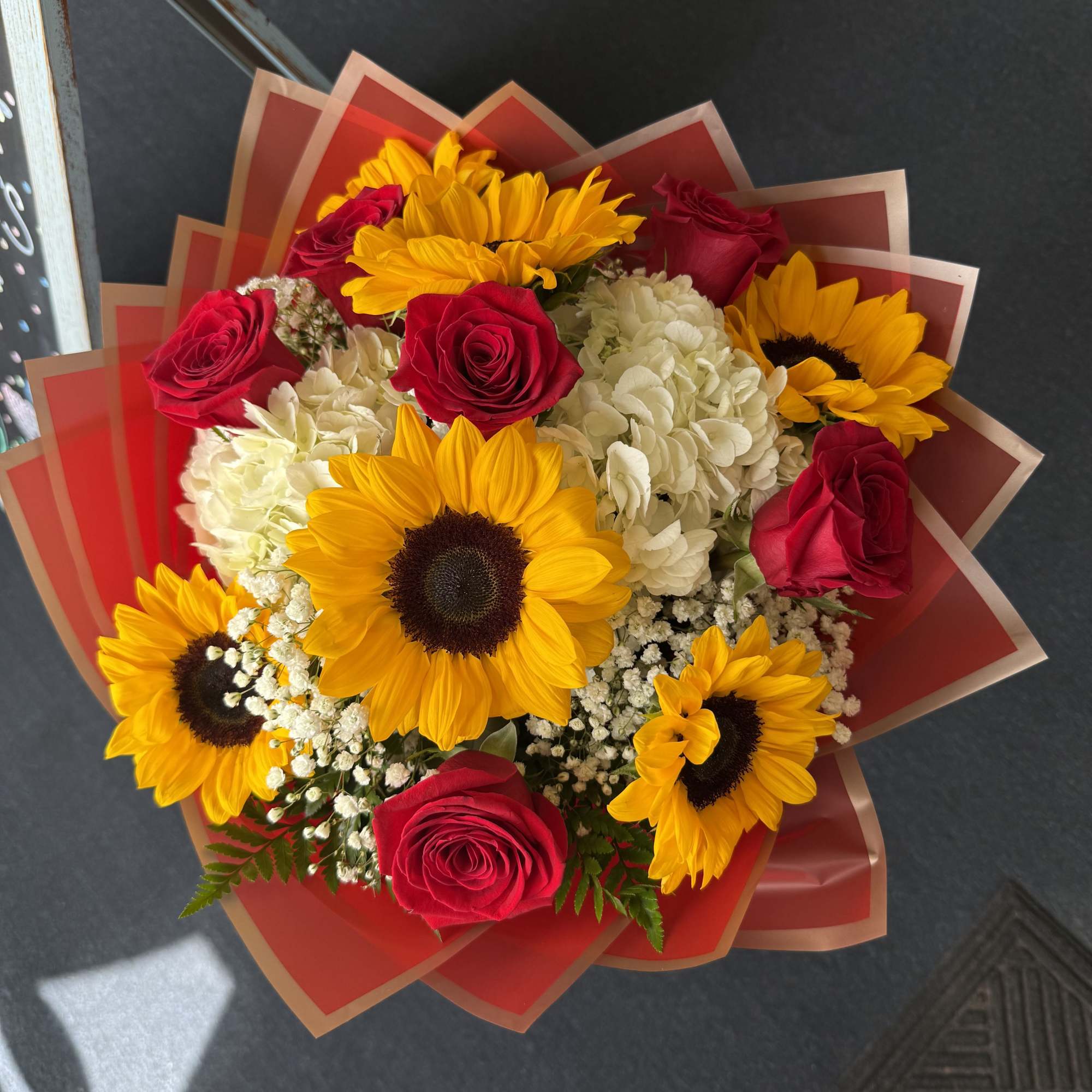 Bright sunflowers, vivid red roses and white accents wrapped in bold red, photo 2 of 2