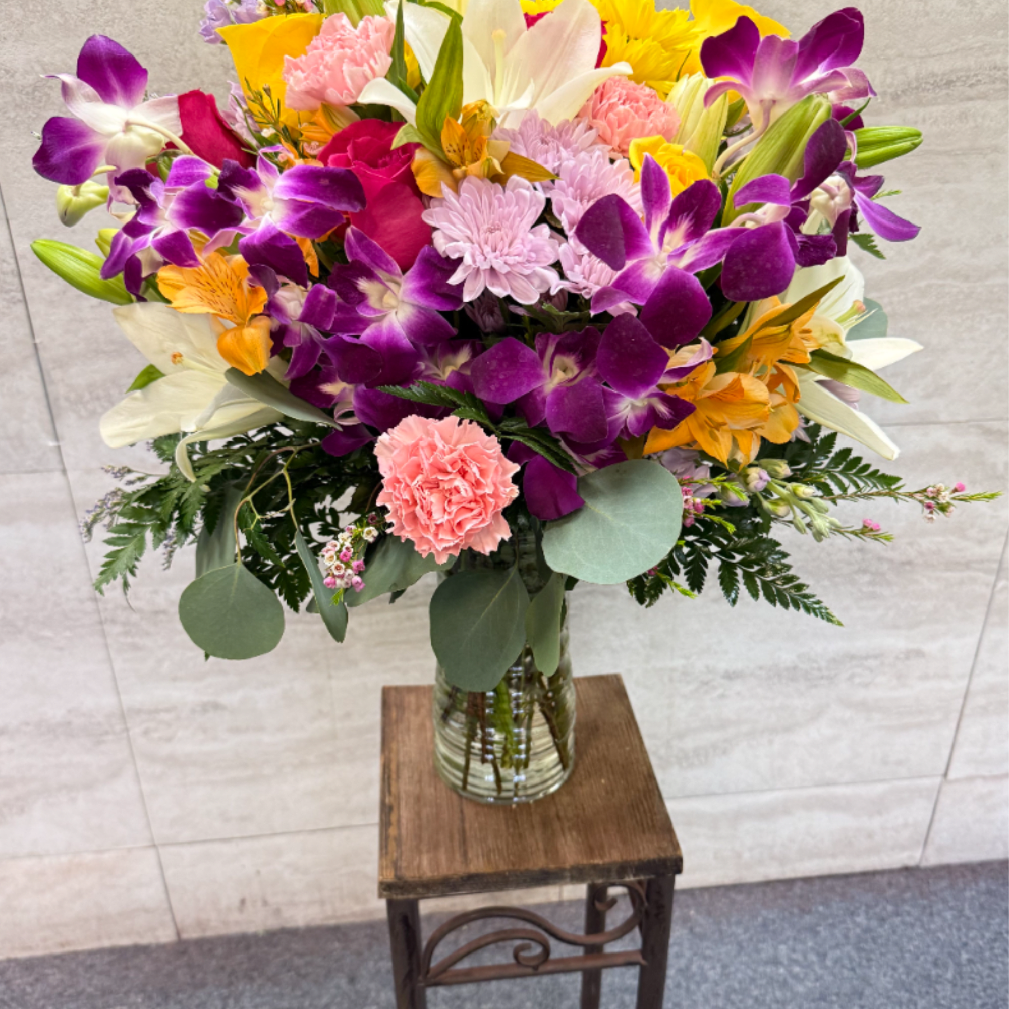 (ALL-ROUND) A vibrant, tropical-inspired bouquet featuring stunning dendros, elegant lilies, and soft