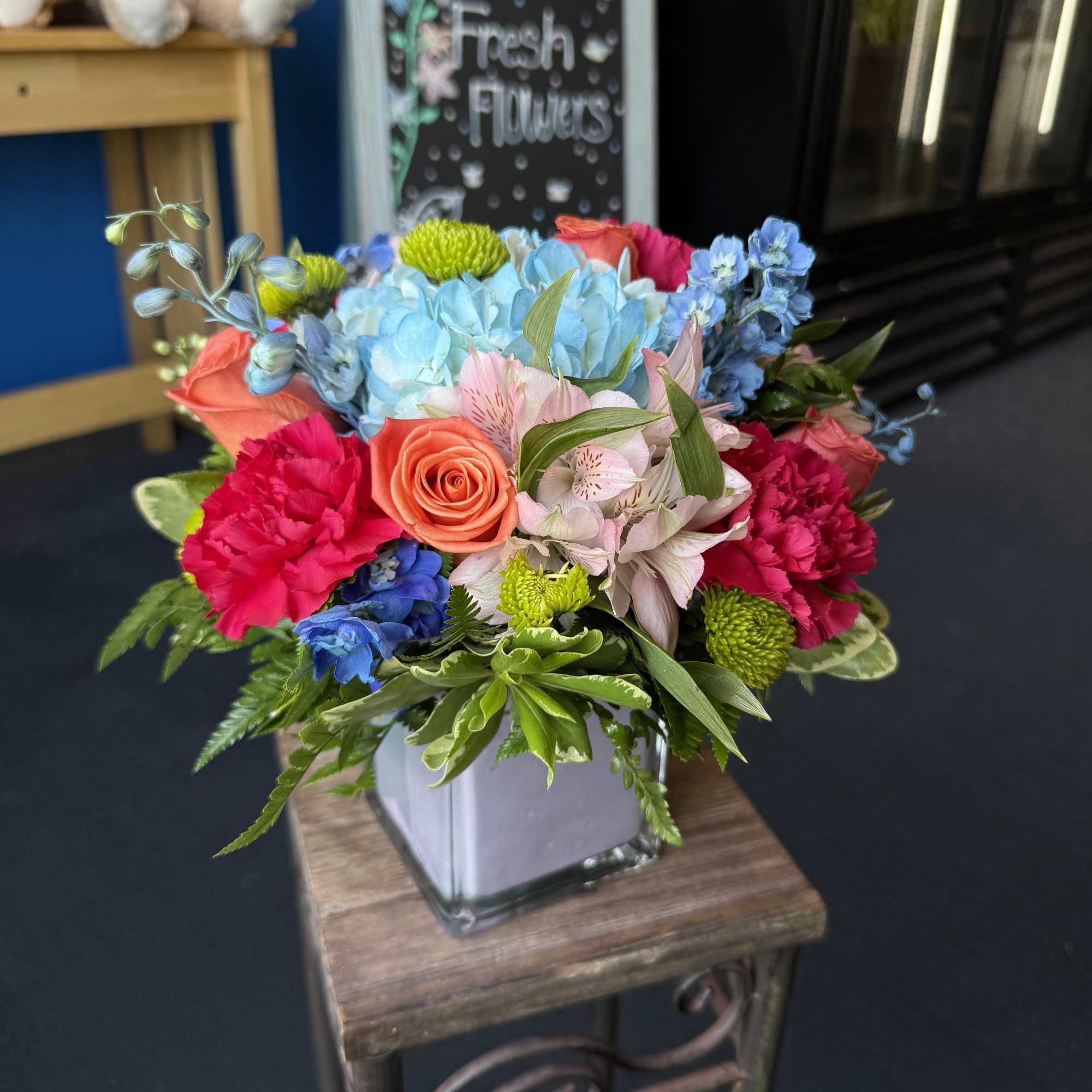Colorful mixed bouquet in a square glass vase