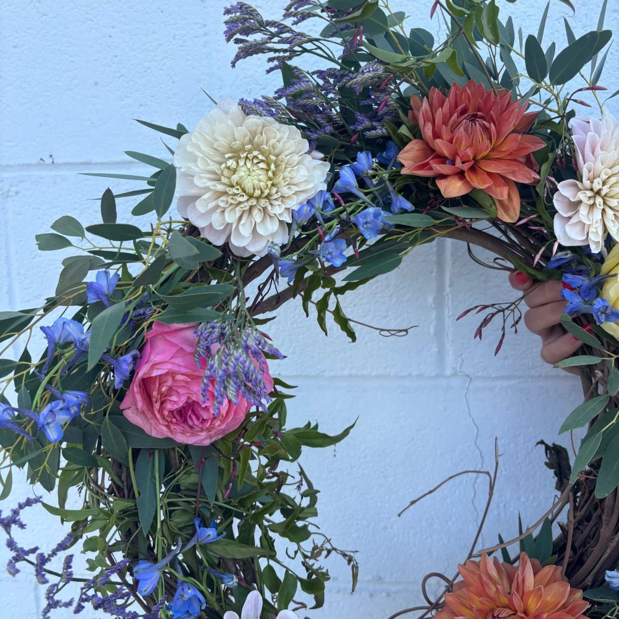 Floral wreath with dahlias, roses, and blue accents