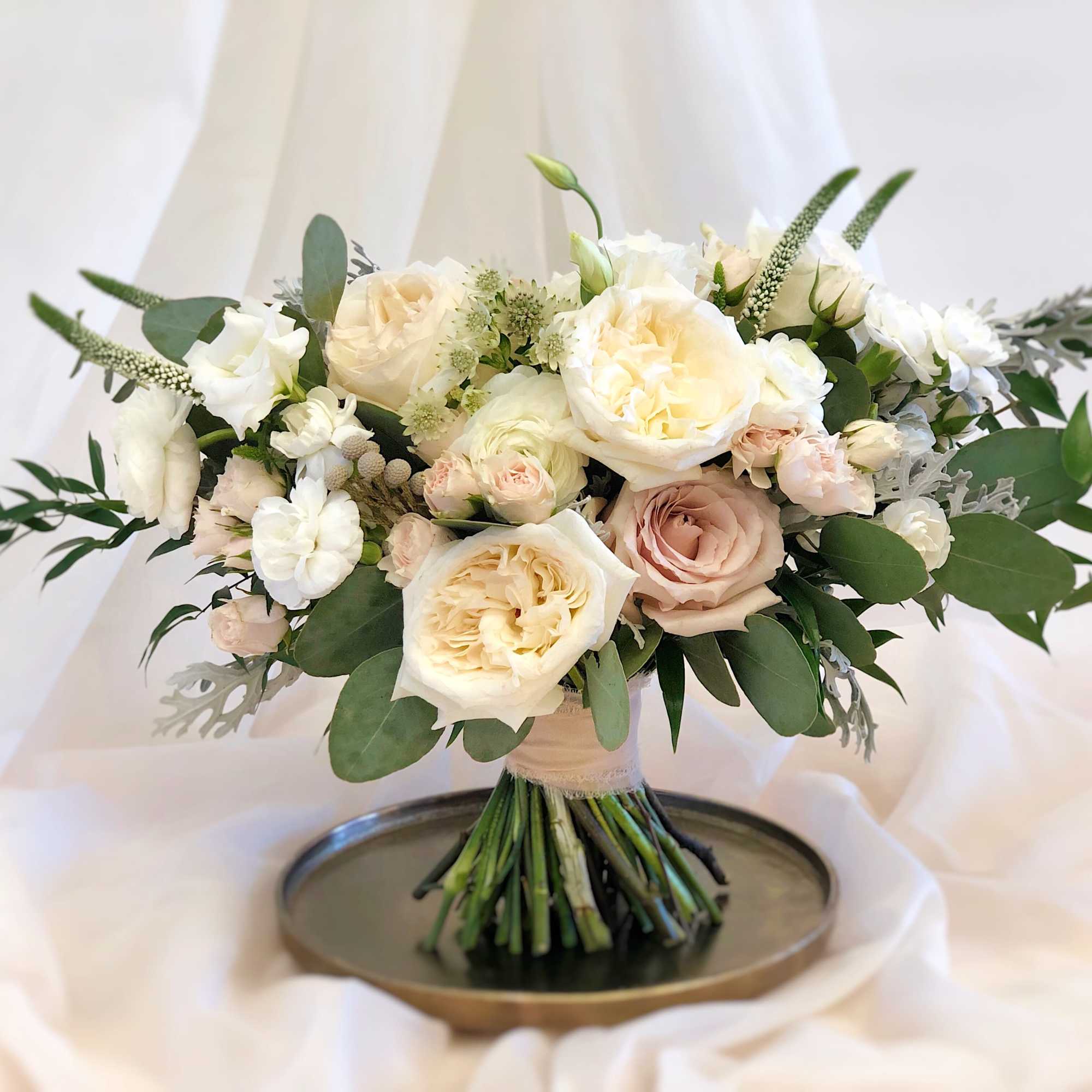 Cream and blush rose bouquet with greenery on a tray