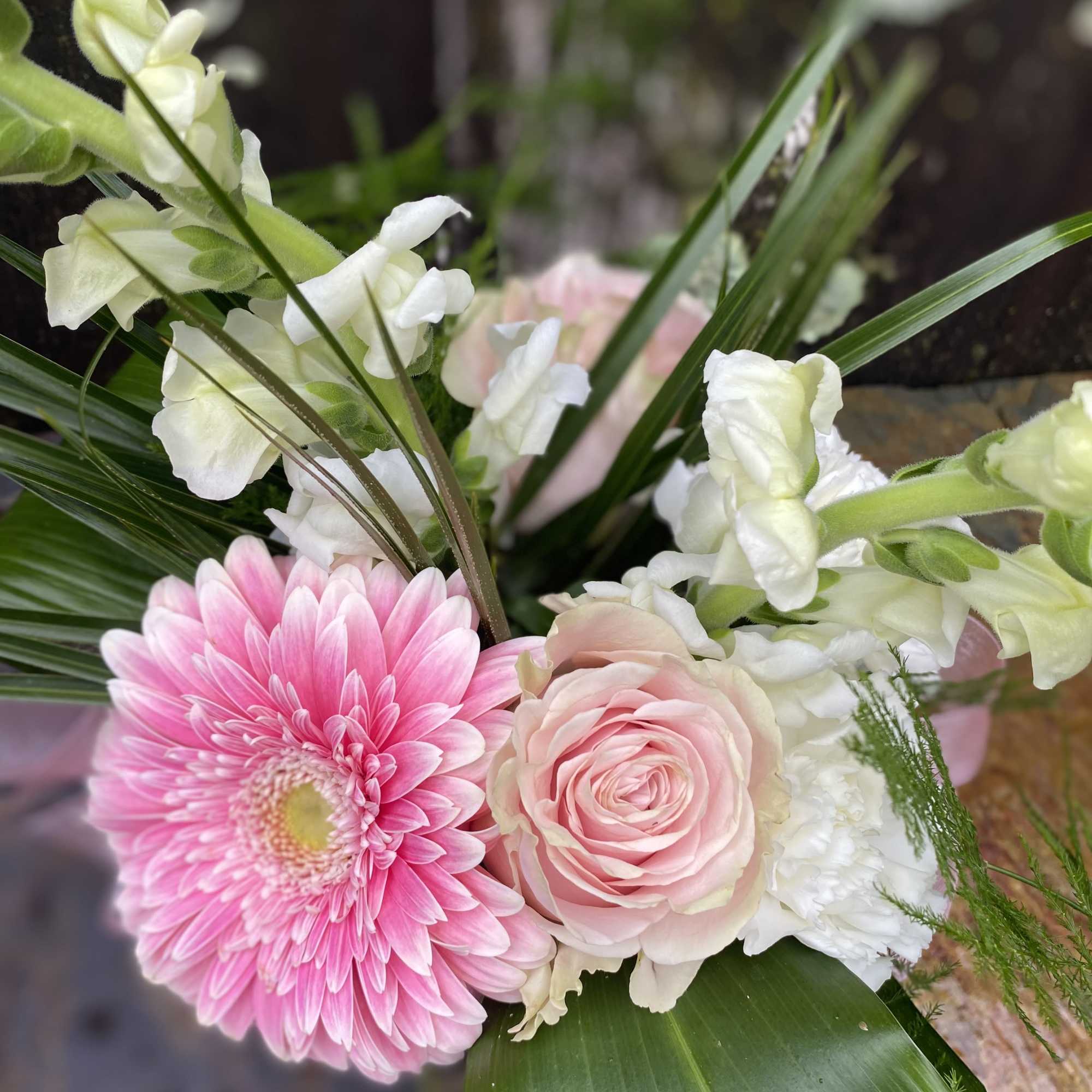 Pink gerbera daisy and pale pink rose bouquet with white snapdragons