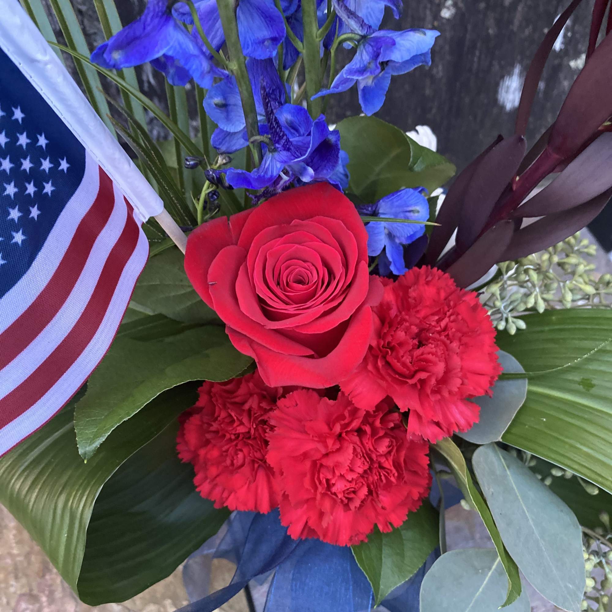 Red rose and carnations with blue flowers and an American flag