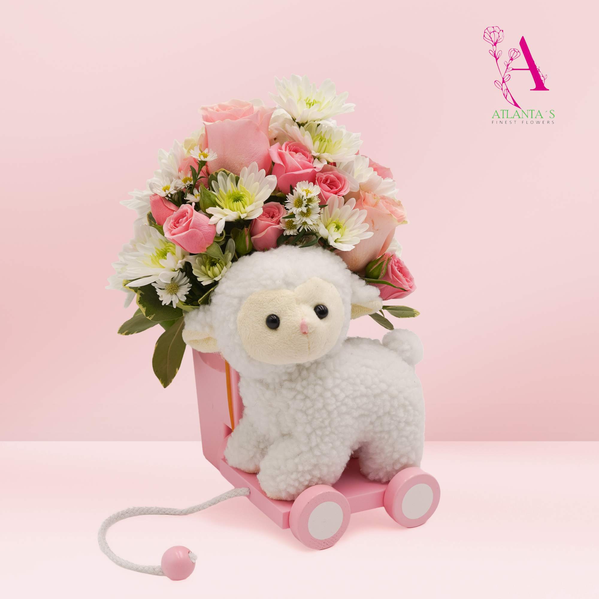 Pink rose bouquet with white daisies and a plush lamb on a pink toy cart