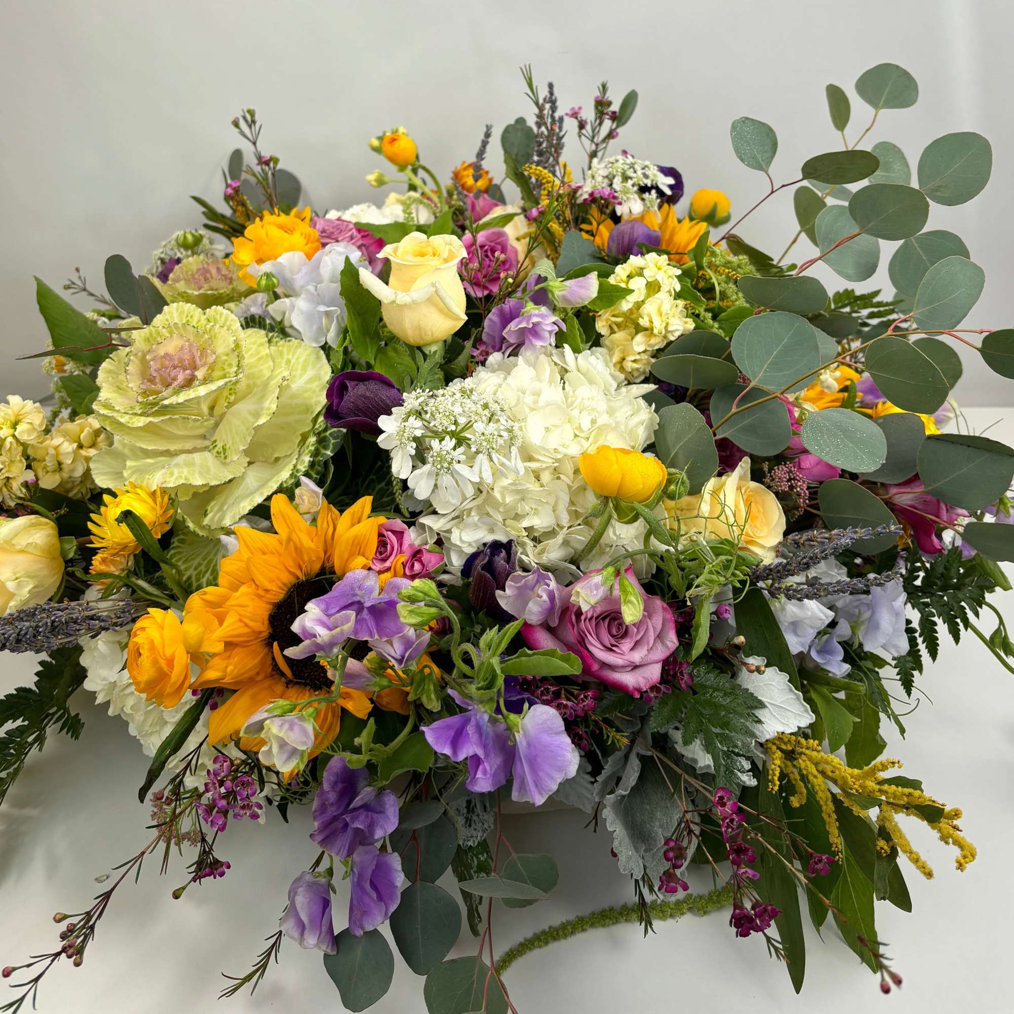 Mixed bouquet with sunflowers, roses, hydrangeas, and purple blooms