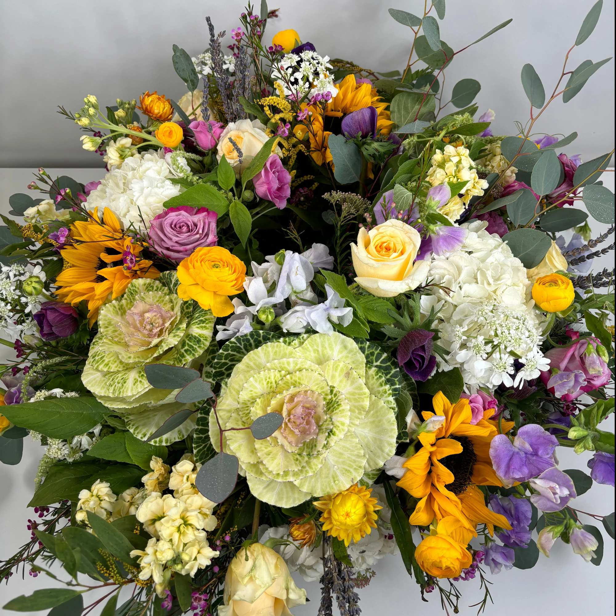 Mixed bouquet with sunflowers, roses, hydrangeas, and ornamental cabbage
