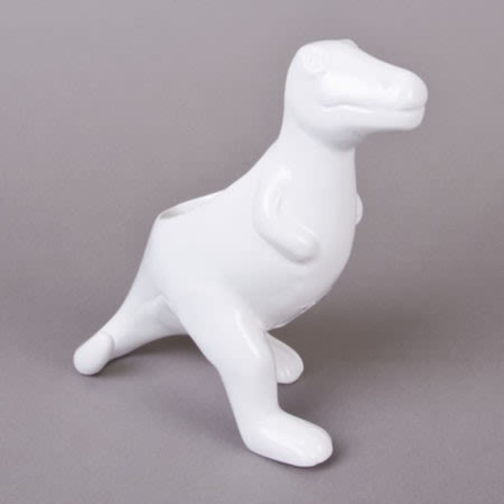 White dinosaur-shaped figurine on a gray background