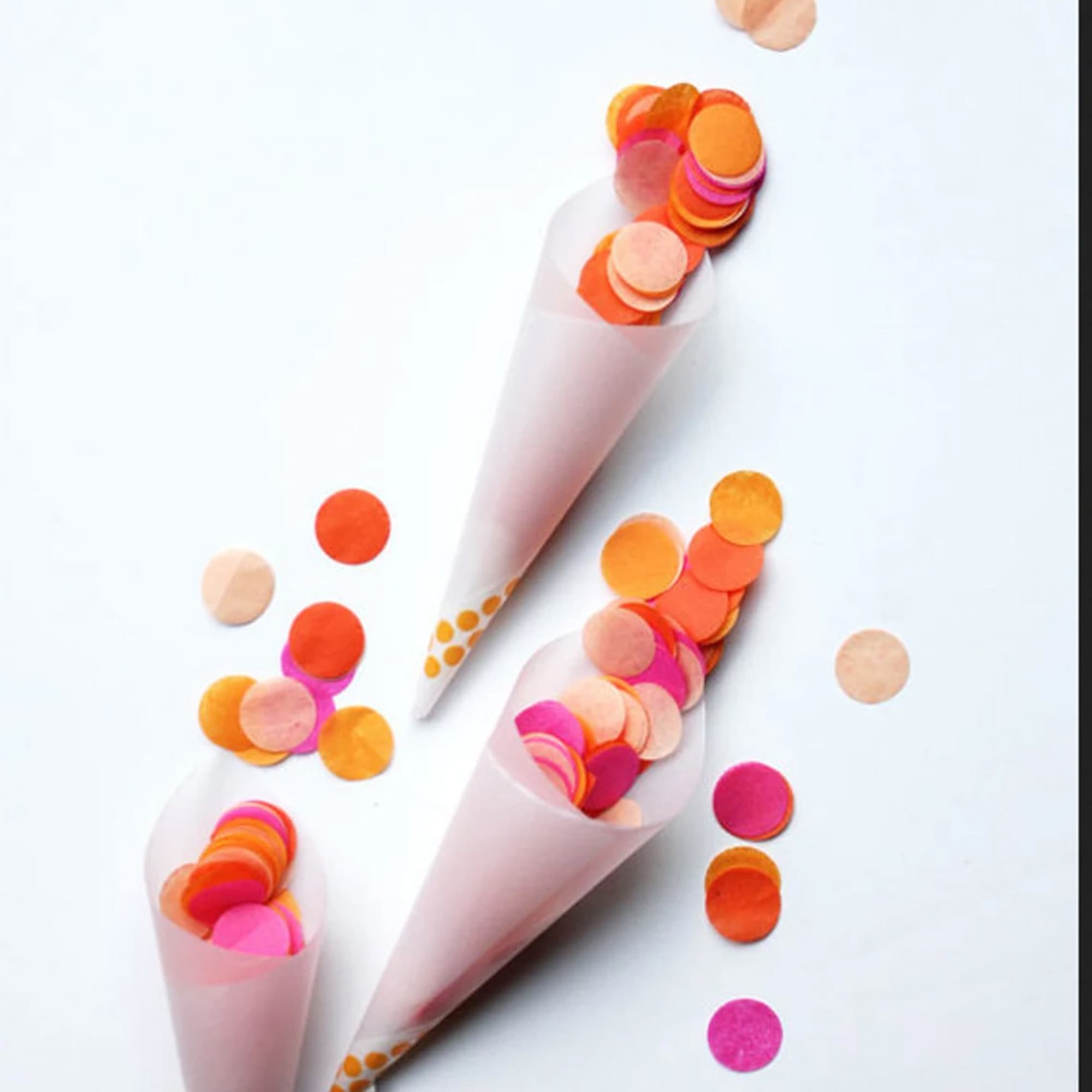 Paper cones filled with colorful confetti dots on a white background