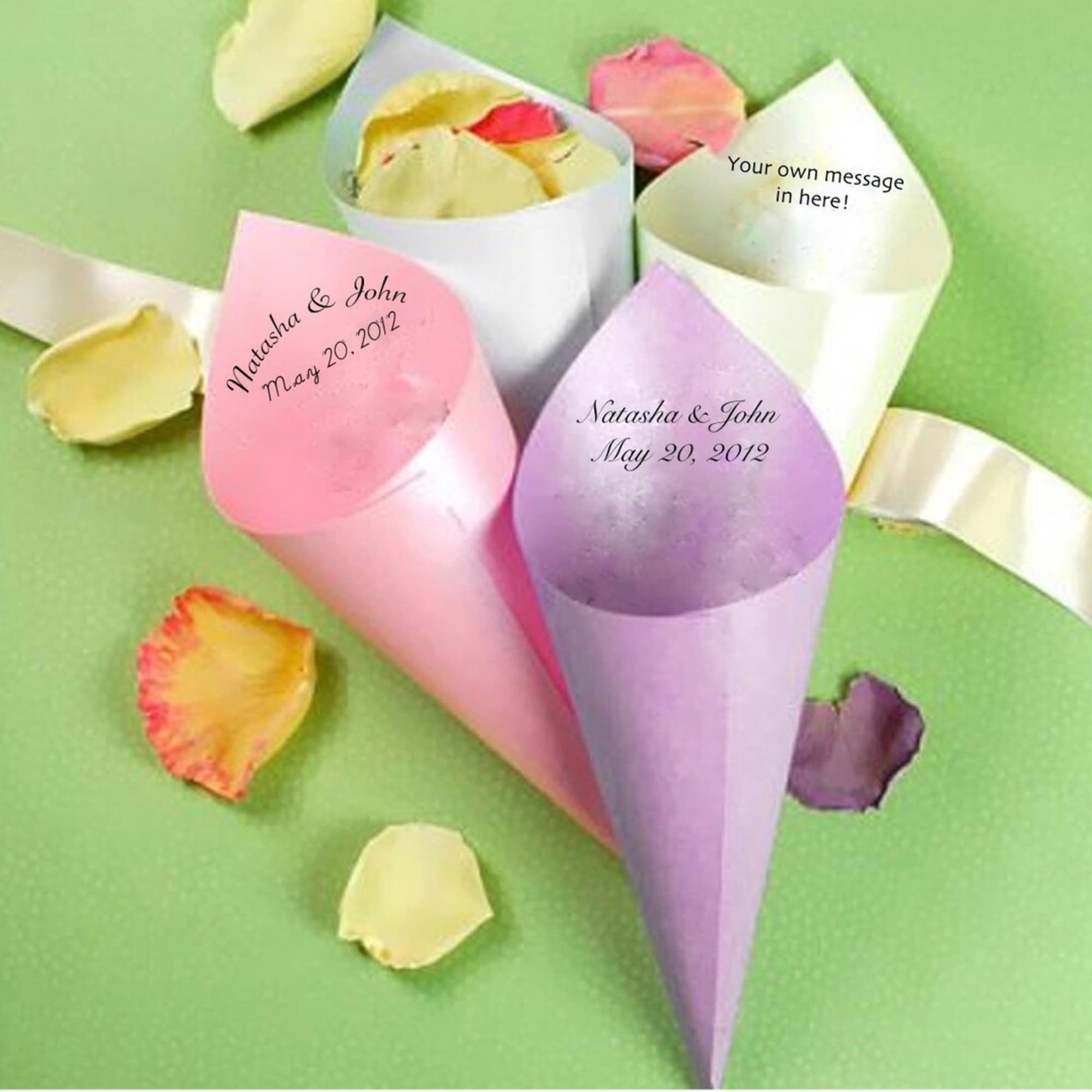 Pastel paper cones holding rose petals on a green background