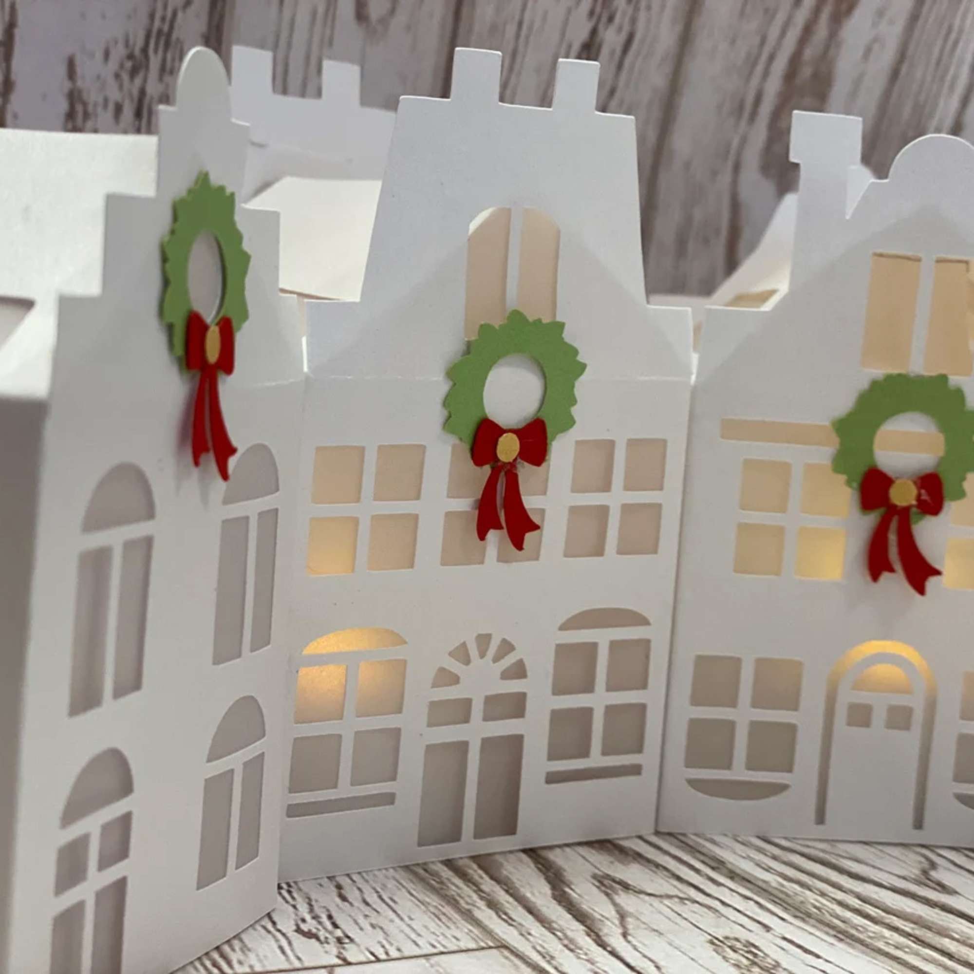 White paper house-shaped gift boxes with small wreath decorations