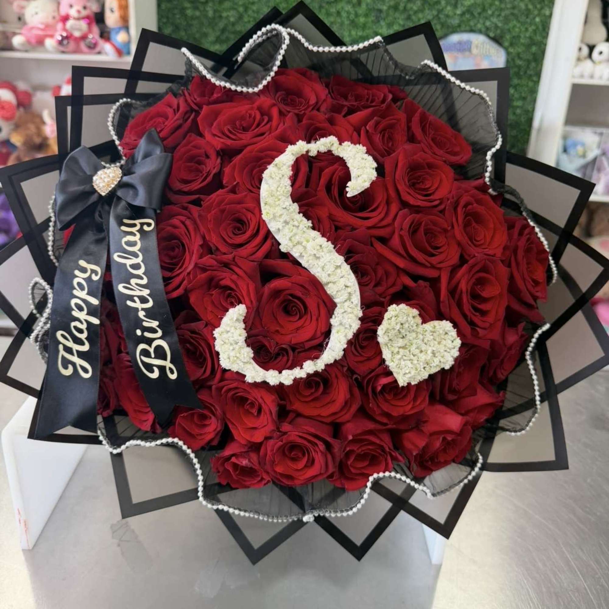 Red rose bouquet with a white floral number 5 and heart, wrapped in black