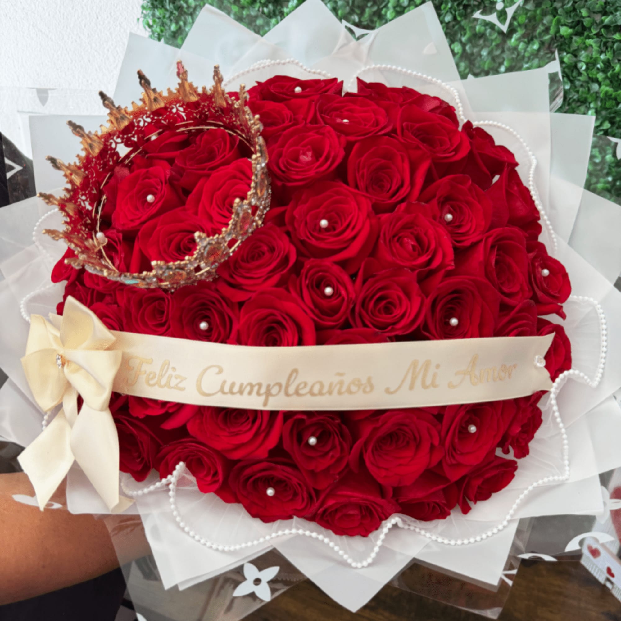 Heart-shaped bouquet of red roses with a small crown and ribbon