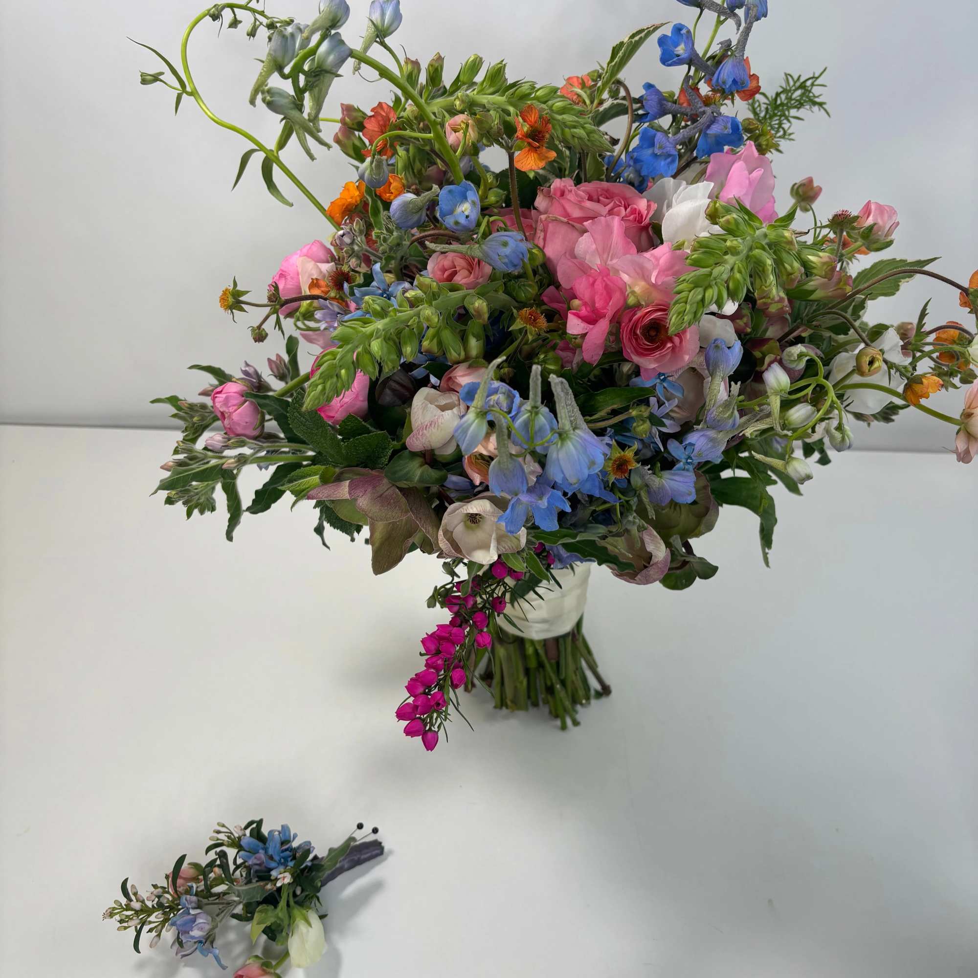 Loose bouquet of pink, blue, and white flowers in a clear vase