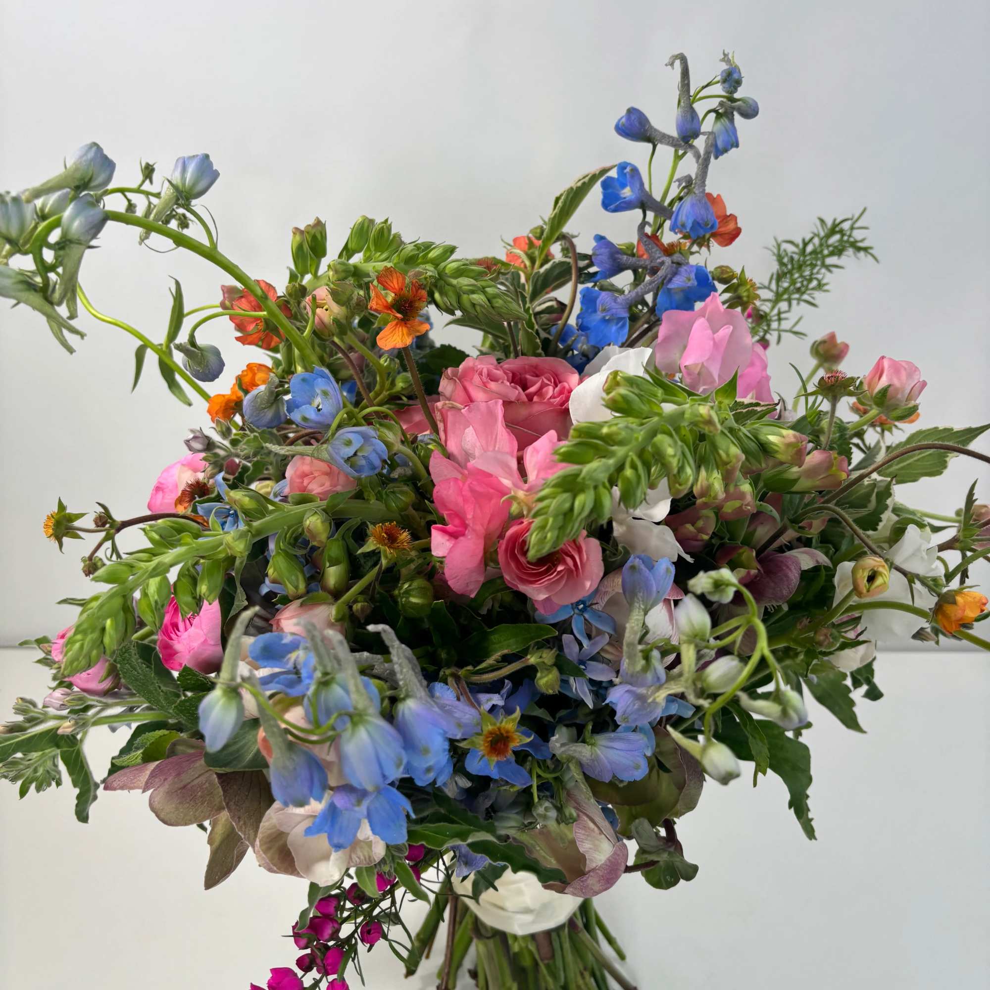 Loose bouquet of pink, blue, and white flowers