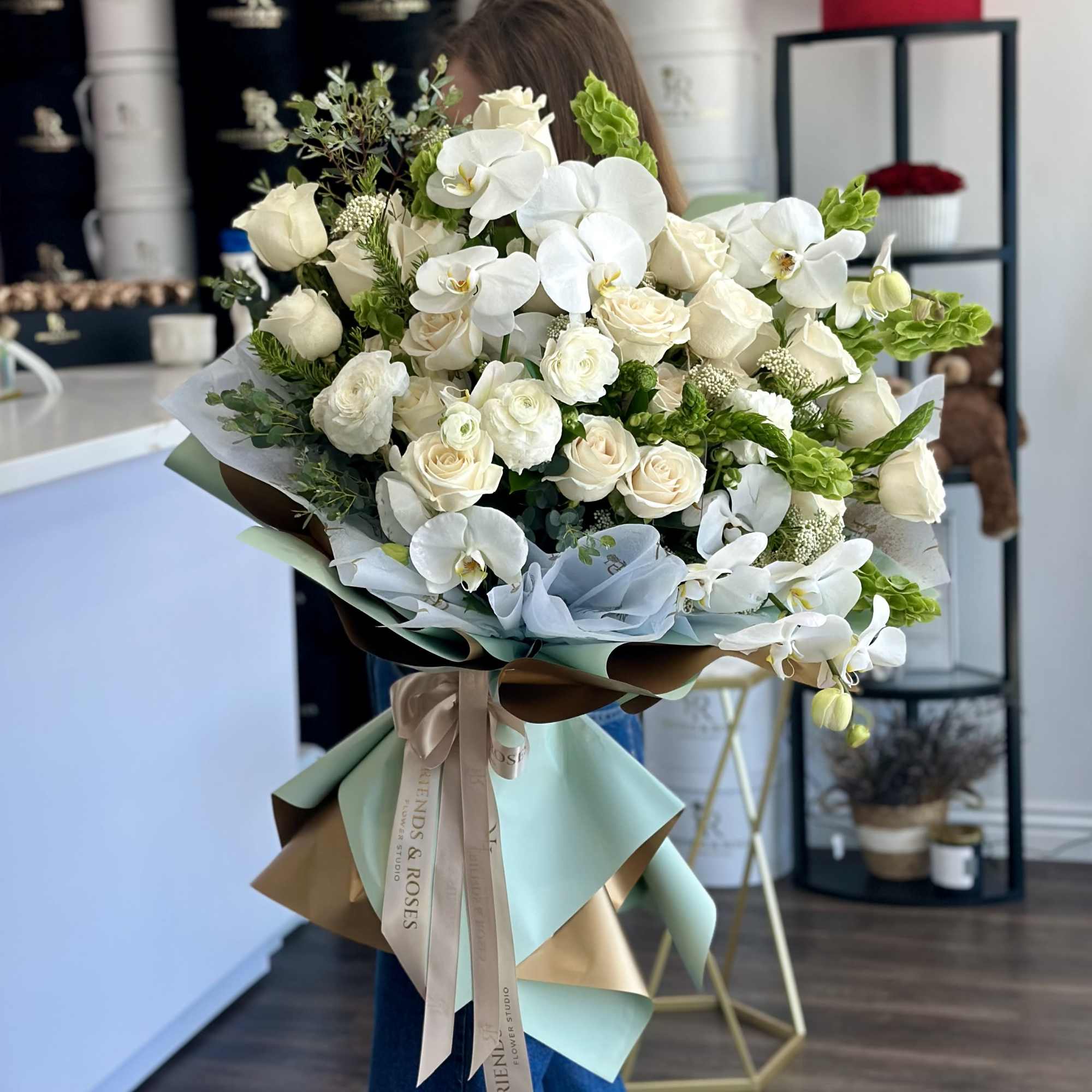 A luxurious and refined floral arrangement featuring pristine white orchids, soft ivory, photo 3 of 3