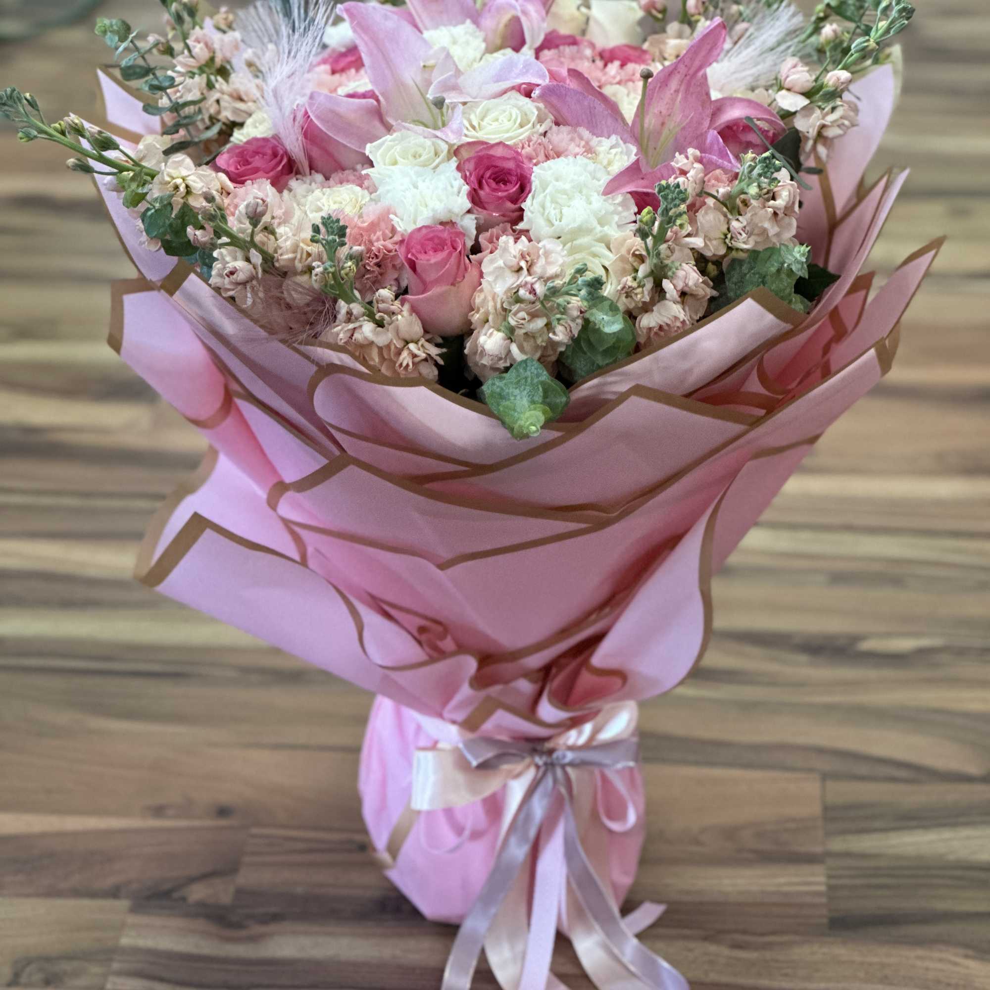 Pink bouquet with roses and lilies wrapped in pink paper