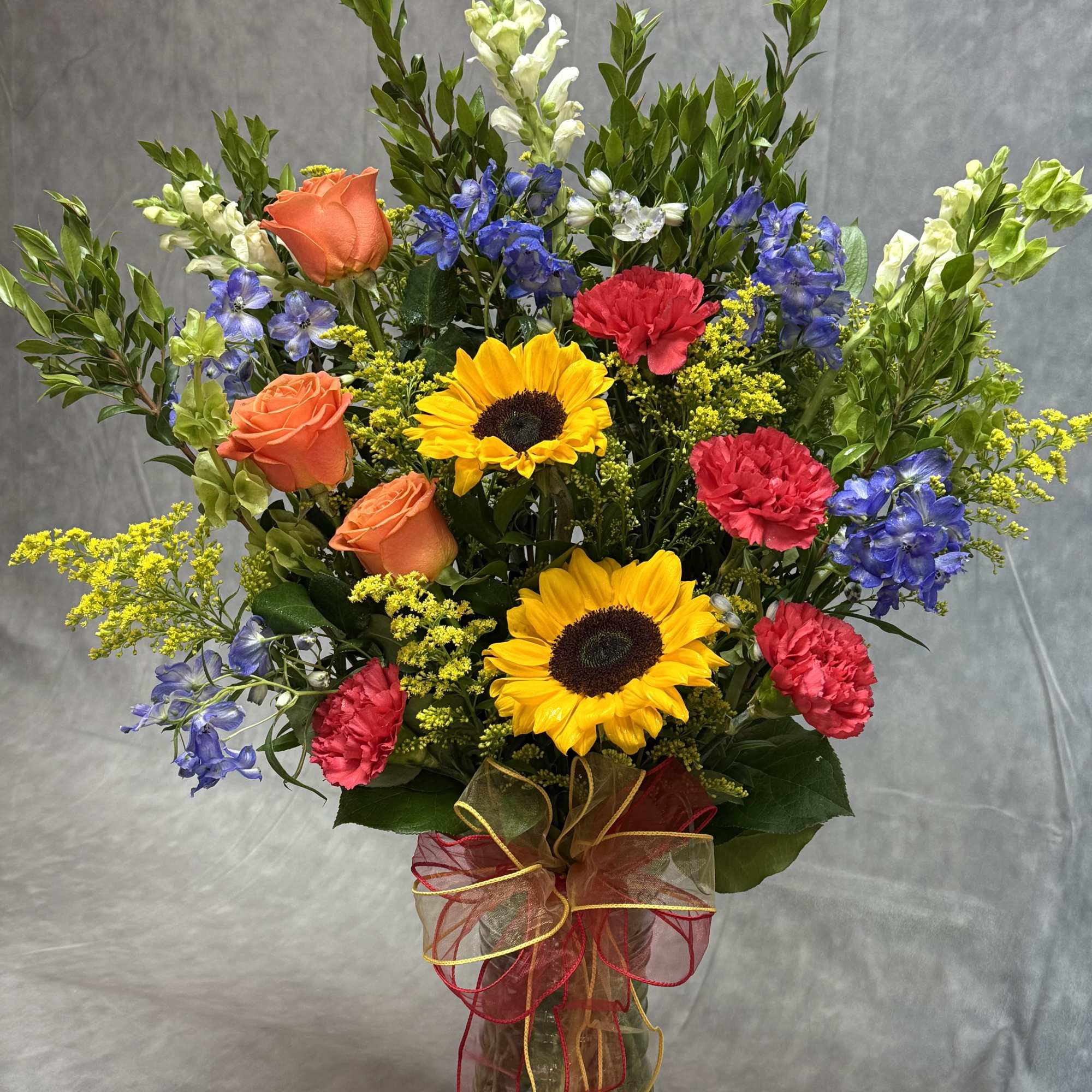 Colorful mixed bouquet in a glass vase with ribbon