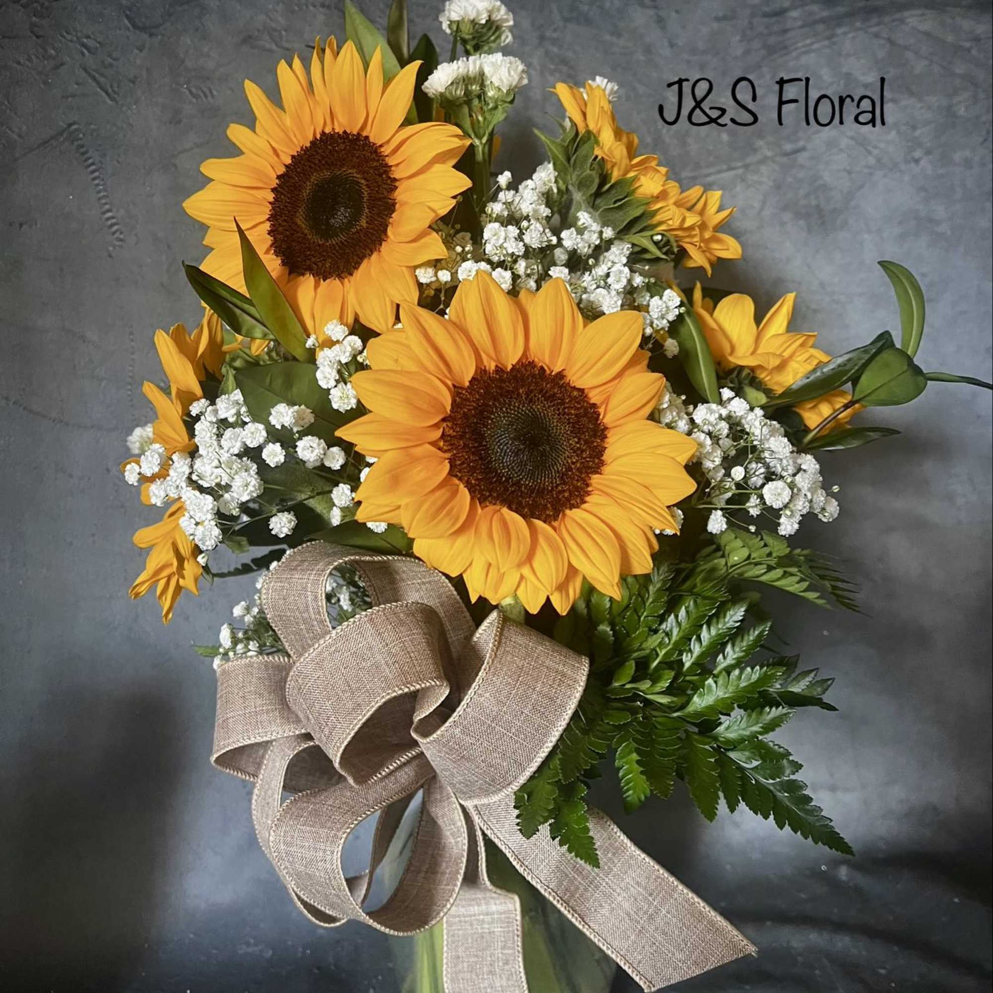 Sunflower bouquet in a glass vase with a burlap ribbon