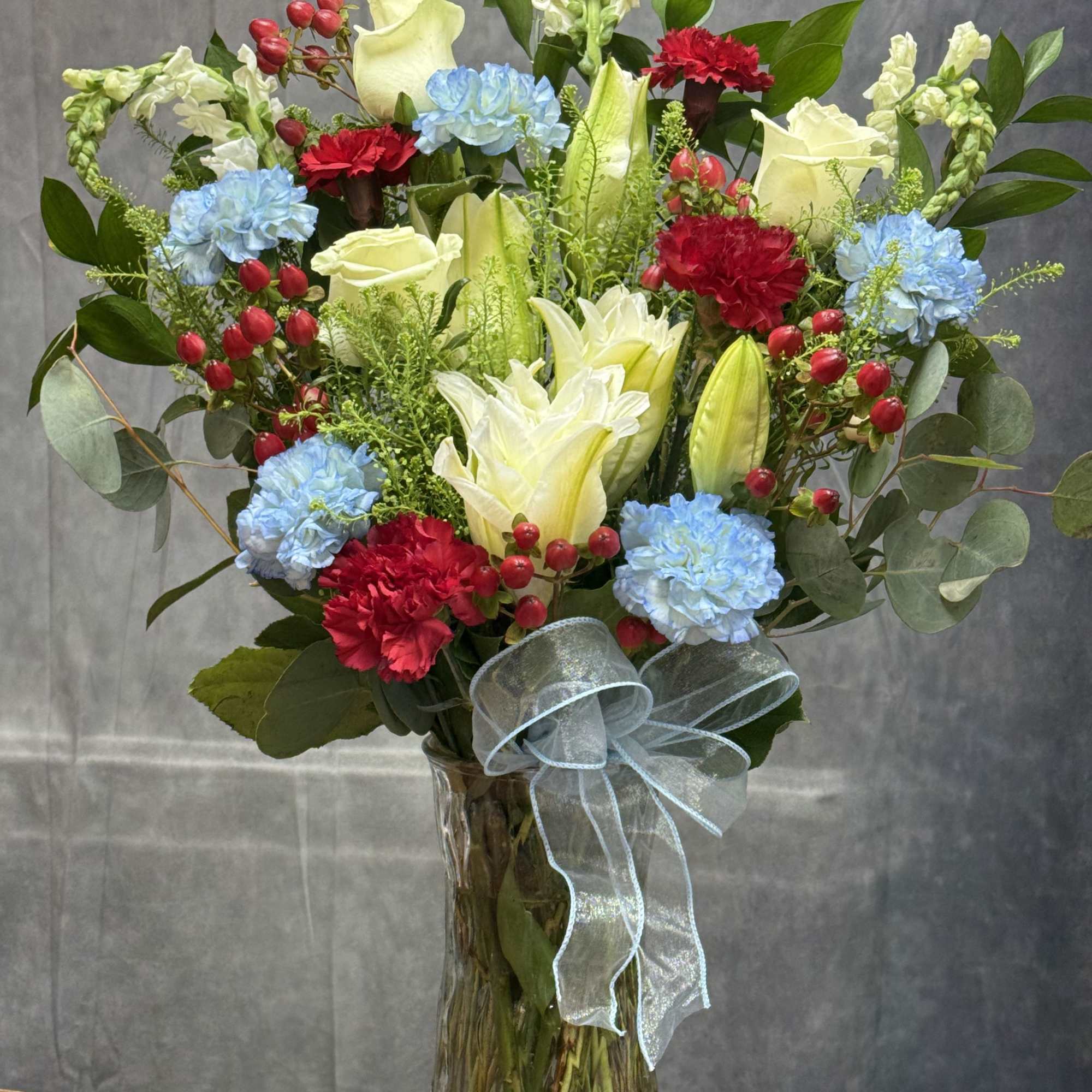 A tall, full Lily of Honor vase arrangement that balances classic white