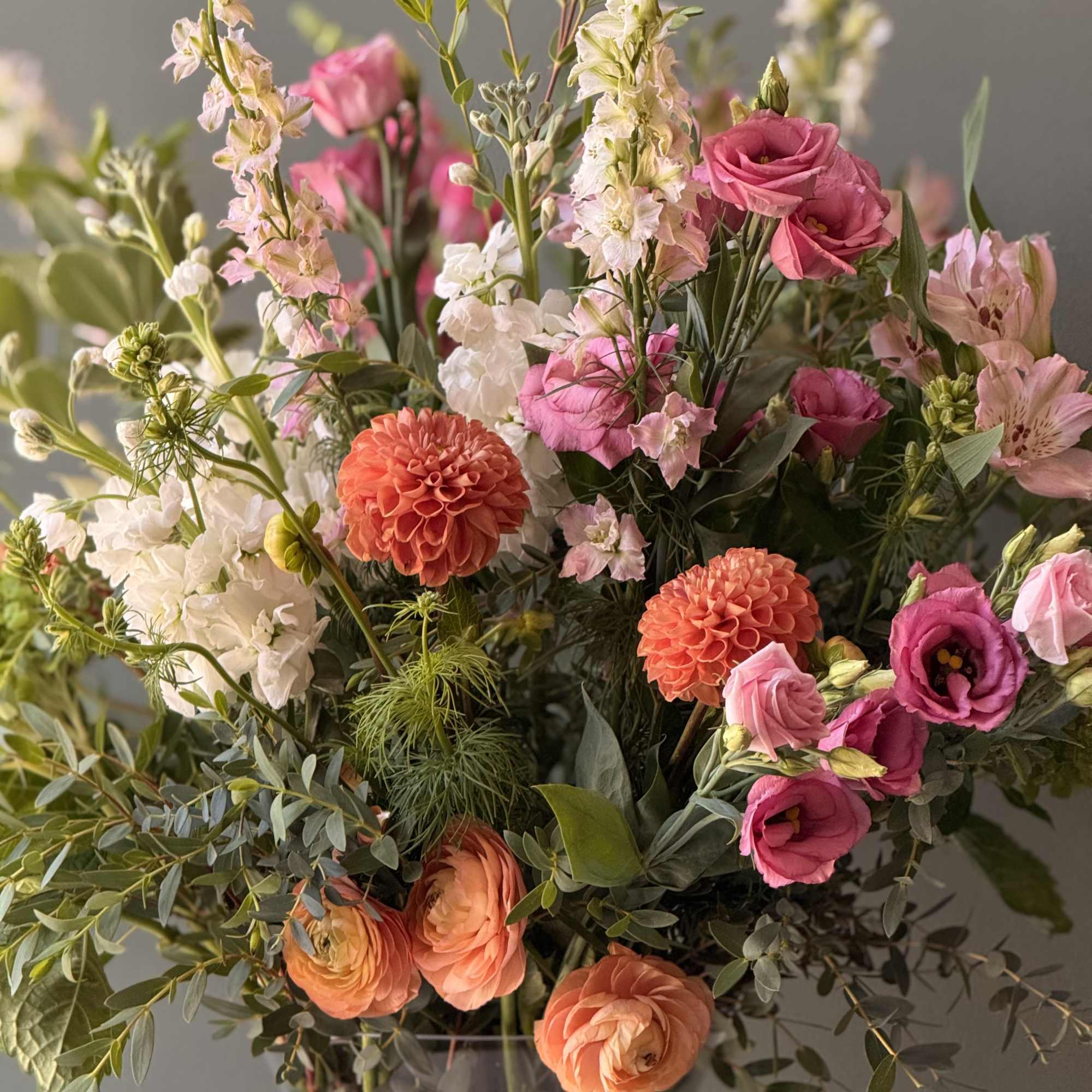 Mixed bouquet of pink, white, and orange flowers in a vase