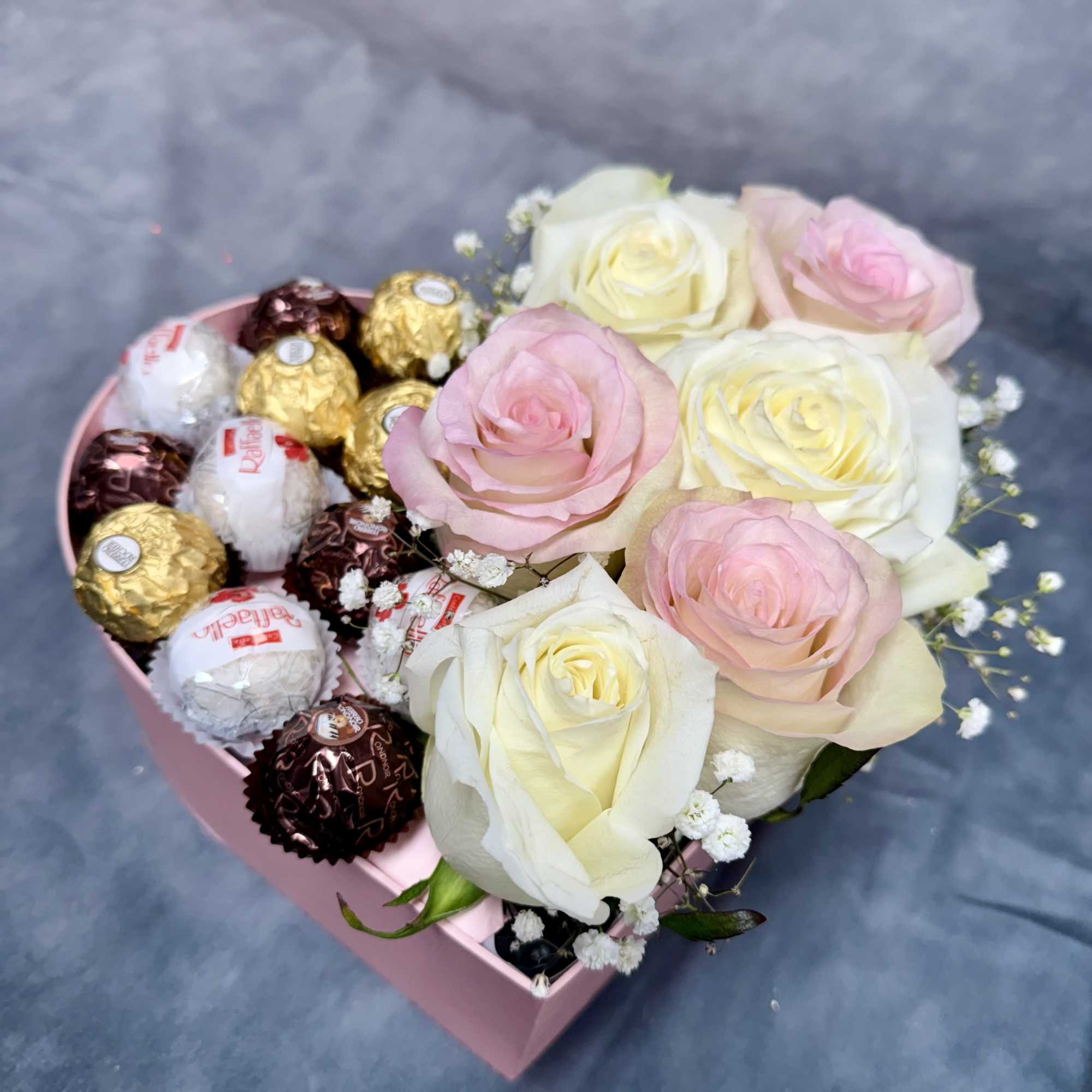 Pink heart-shaped box with roses and assorted chocolates