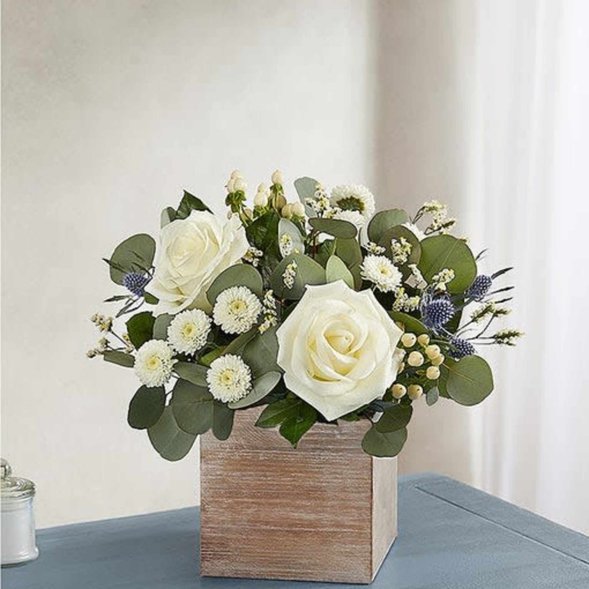 White roses, thistle blue,white limonium, white button pom,cream hypericum, succulent, eucalyptus silver