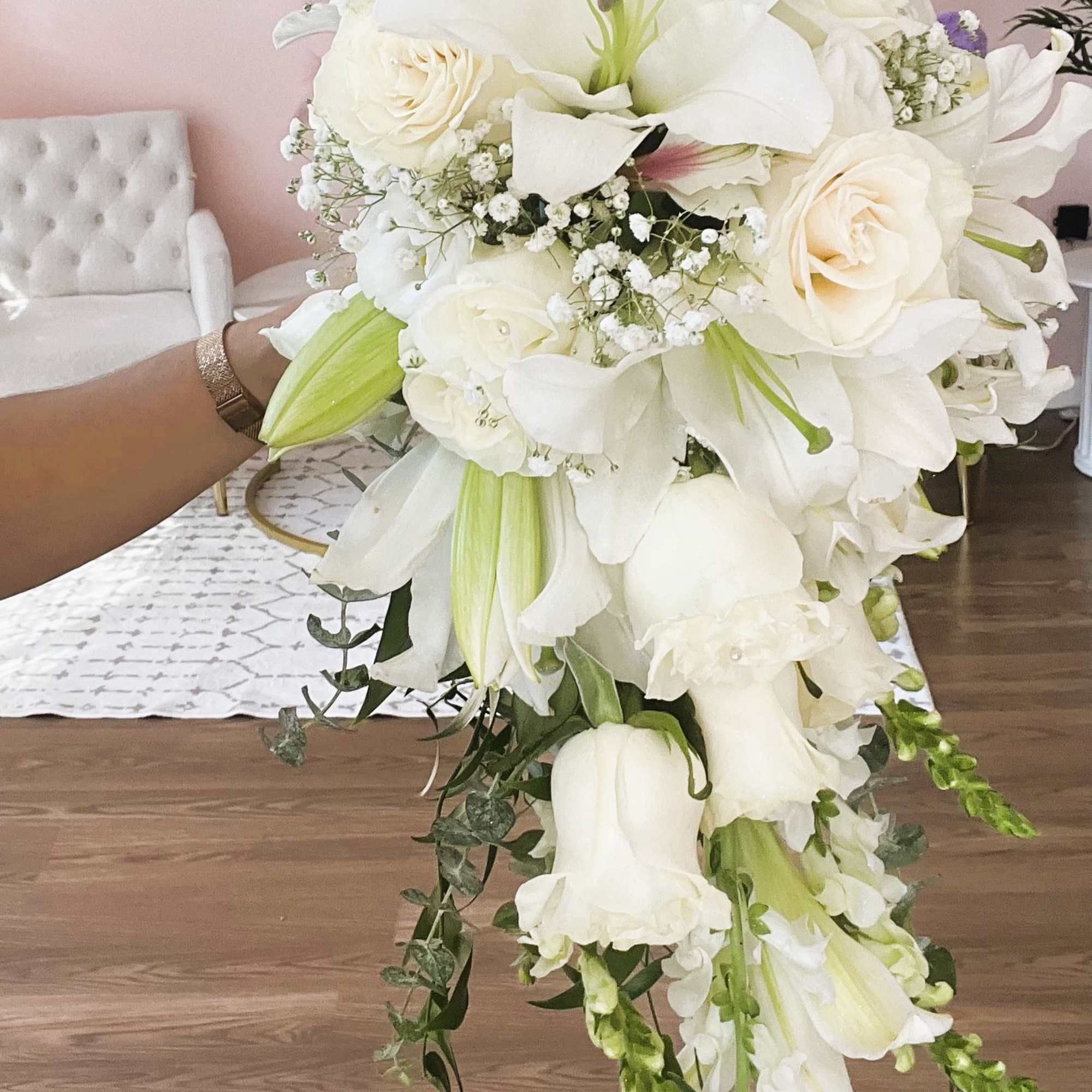 White bridal bouquet with lilies, roses, and trailing flowers